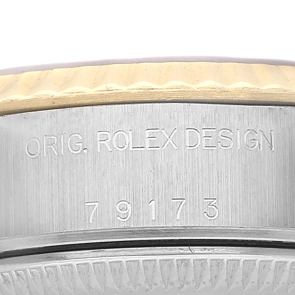 The image shows the side of a Rolex Datejust 79173 Women's Steel and Gold (two tone) Black Dial, highlighting the engraved design number and edge of the bezel.