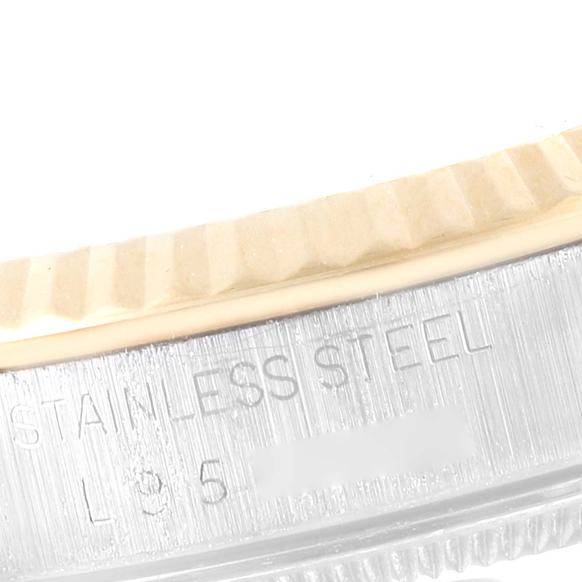 The image shows a close-up of the side of the bezel and case of a Rolex Datejust 16233 Men's Steel and Gold (two tone) Champagne Dial 16233 Men's Steel and Gold (two tone) Champagne Dial watch, with the words "STAINLESS STEEL" engraved.