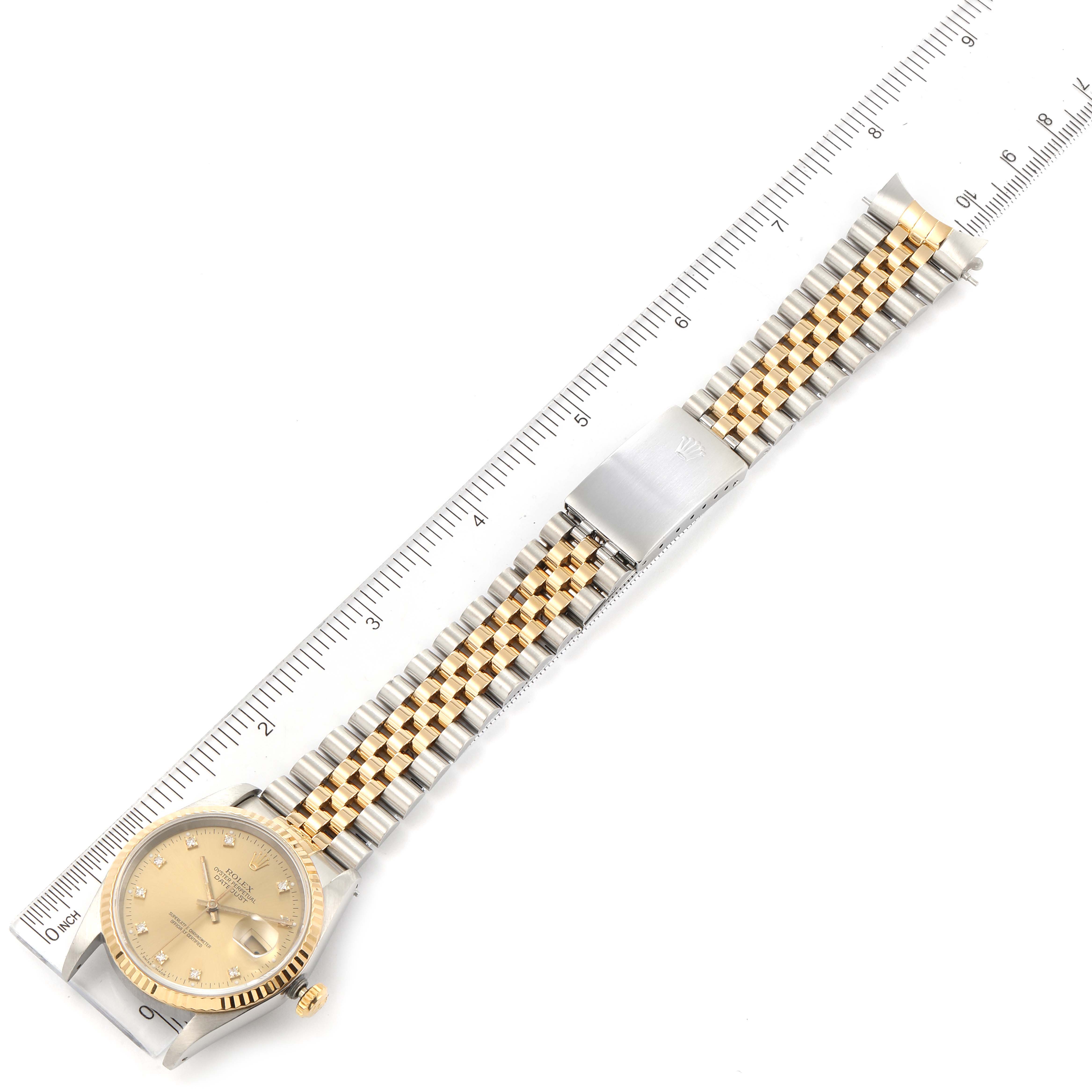 The Rolex Datejust 16233 Men's Steel and Gold (two tone) Champagne Dial 16233 Men's Steel and Gold (two tone) Champagne Dial watch is shown laid flat, displaying the dial, bracelet, clasp, and case, with a ruler for scale.