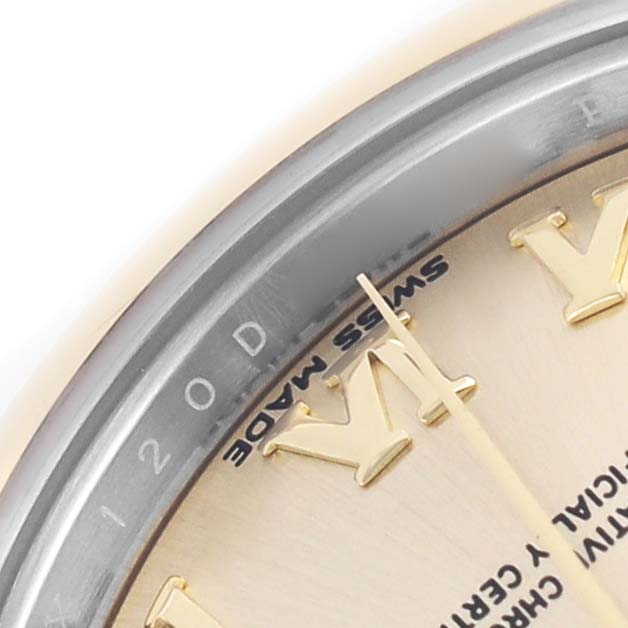 The image shows a partial close-up of a Rolex Datejust 279163 Women's Steel and Gold (two tone) Champagne Dial watch, highlighting the bezel and part of the dial with Roman numerals.