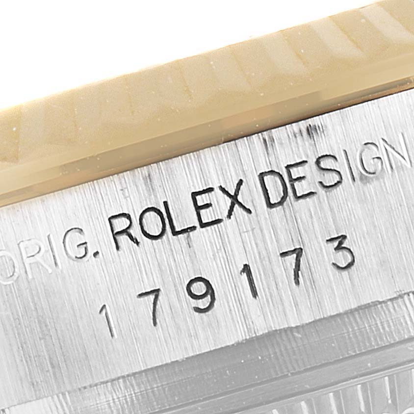 This image shows a close-up of the serial number and engraving on the case side of a Rolex Datejust 179173 Women's Steel and Gold (two tone) Pink Dial 179173 Women's Steel and Gold (two tone) Pink Dial watch.