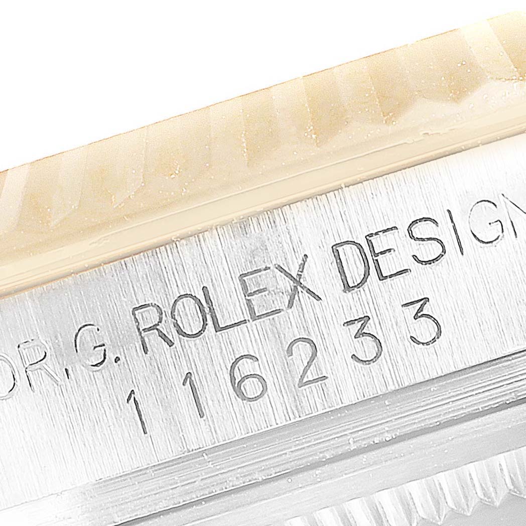 This close-up image shows the serial number engraving on the side of a Rolex Datejust 116233 Men's Steel and Gold (two tone) Grey Dial 116233 Men's Steel and Gold (two tone) Grey Dial model.