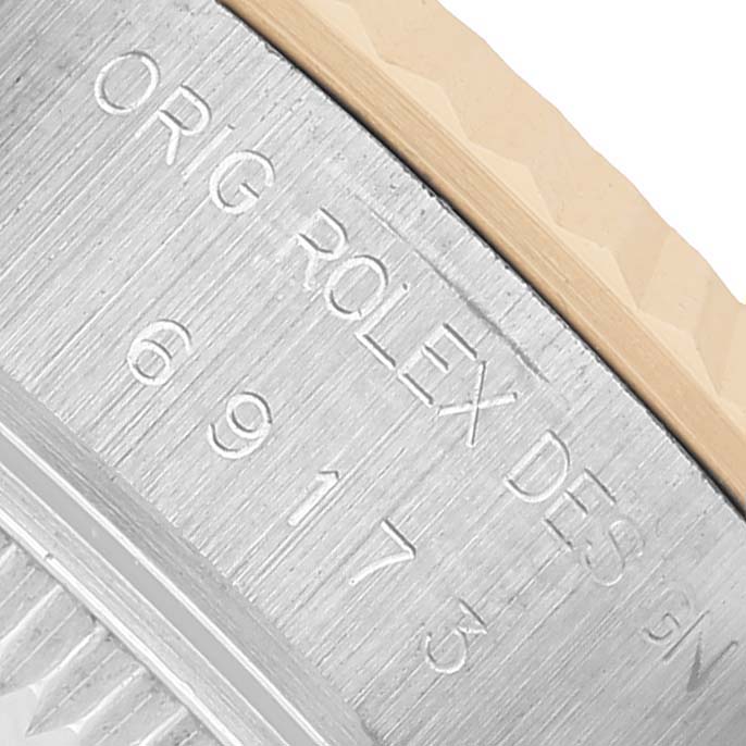 The image shows a close-up side view of a Datejust model by Rolex, focusing on the engraved bezel and case edge.