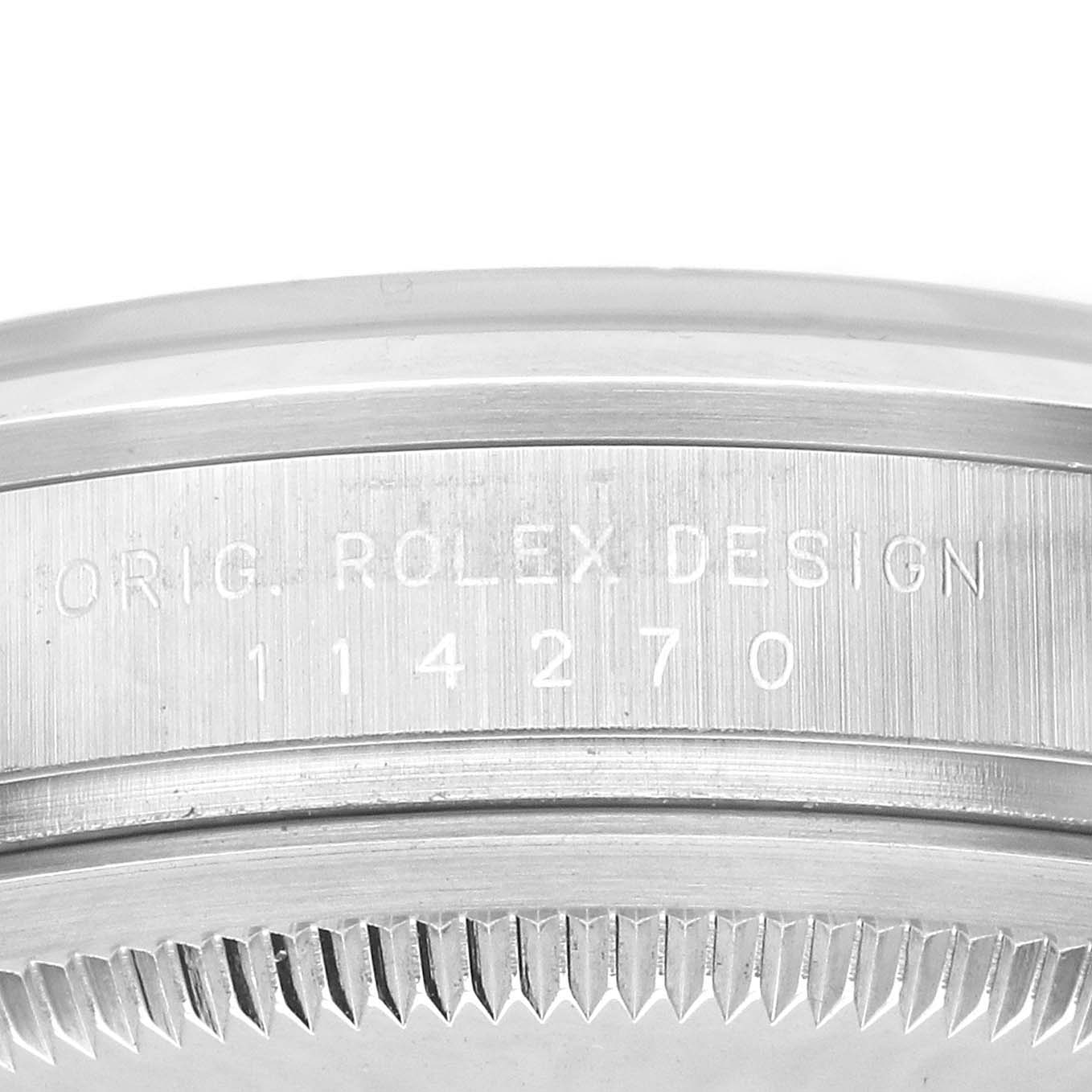 The image shows a close-up of the Rolex Explorer 114270 Men's Stainless Steel Black Dial watch's side, highlighting the engraved design number on the bezel edge.