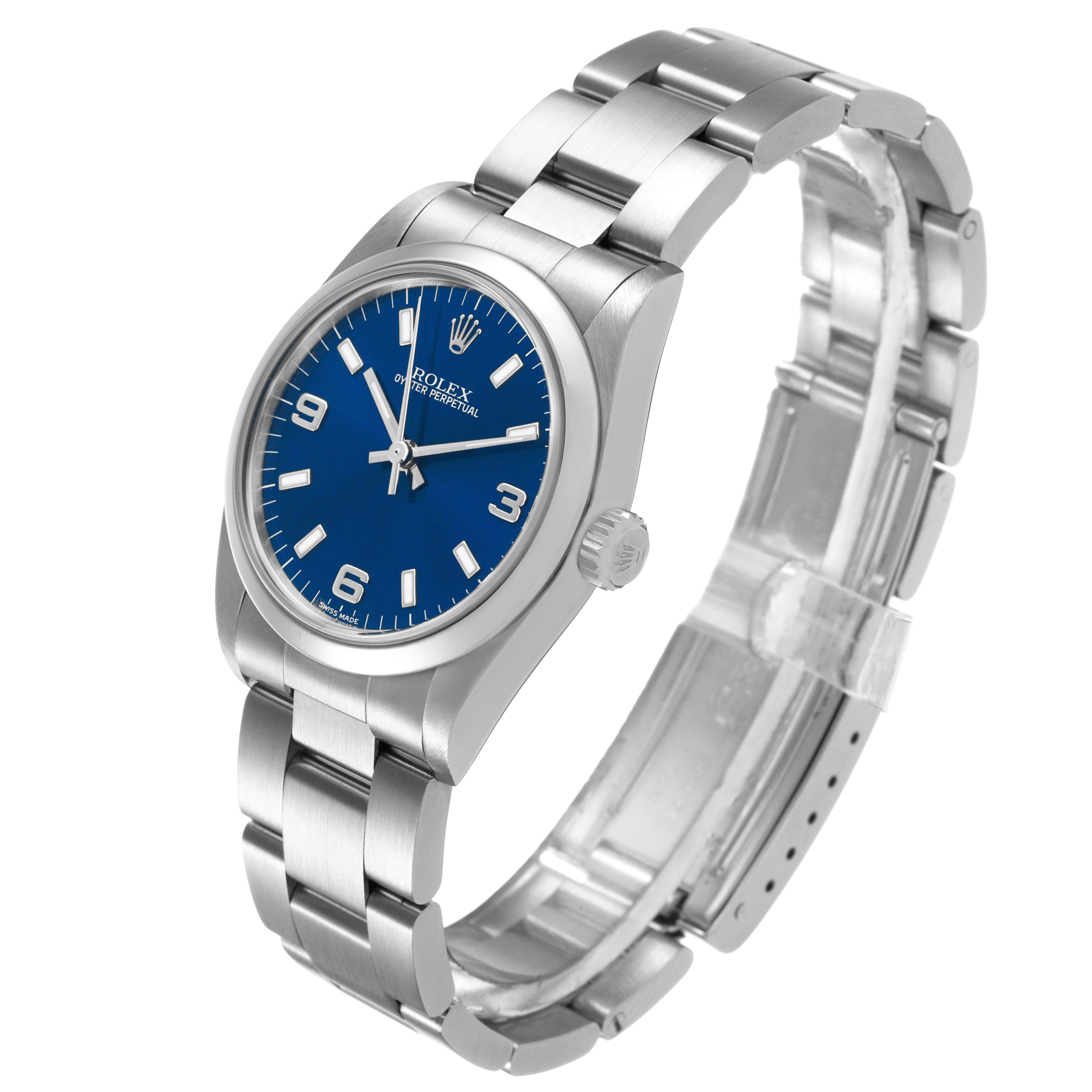 The Rolex Oyster Perpetual 77080 Women's Stainless Steel Blue Dial watch is shown at a three-quarter angle, highlighting the blue dial, bracelet, and crown.