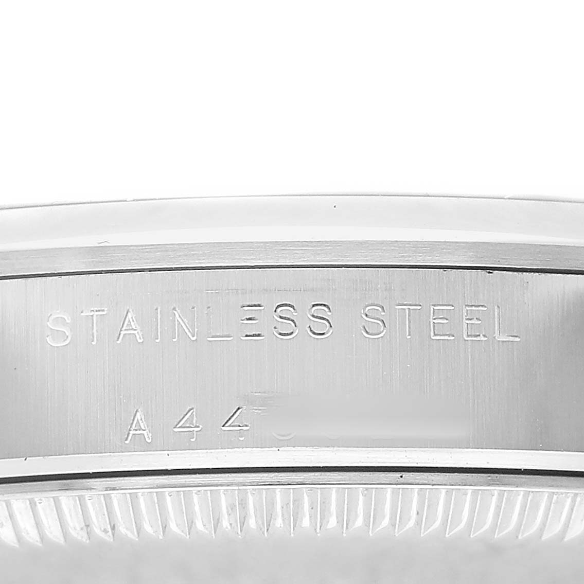 The image shows a close-up of the case side of a Rolex Oyster Perpetual 77080 Women's Stainless Steel Blue Dial, displaying "Stainless Steel" engraving.