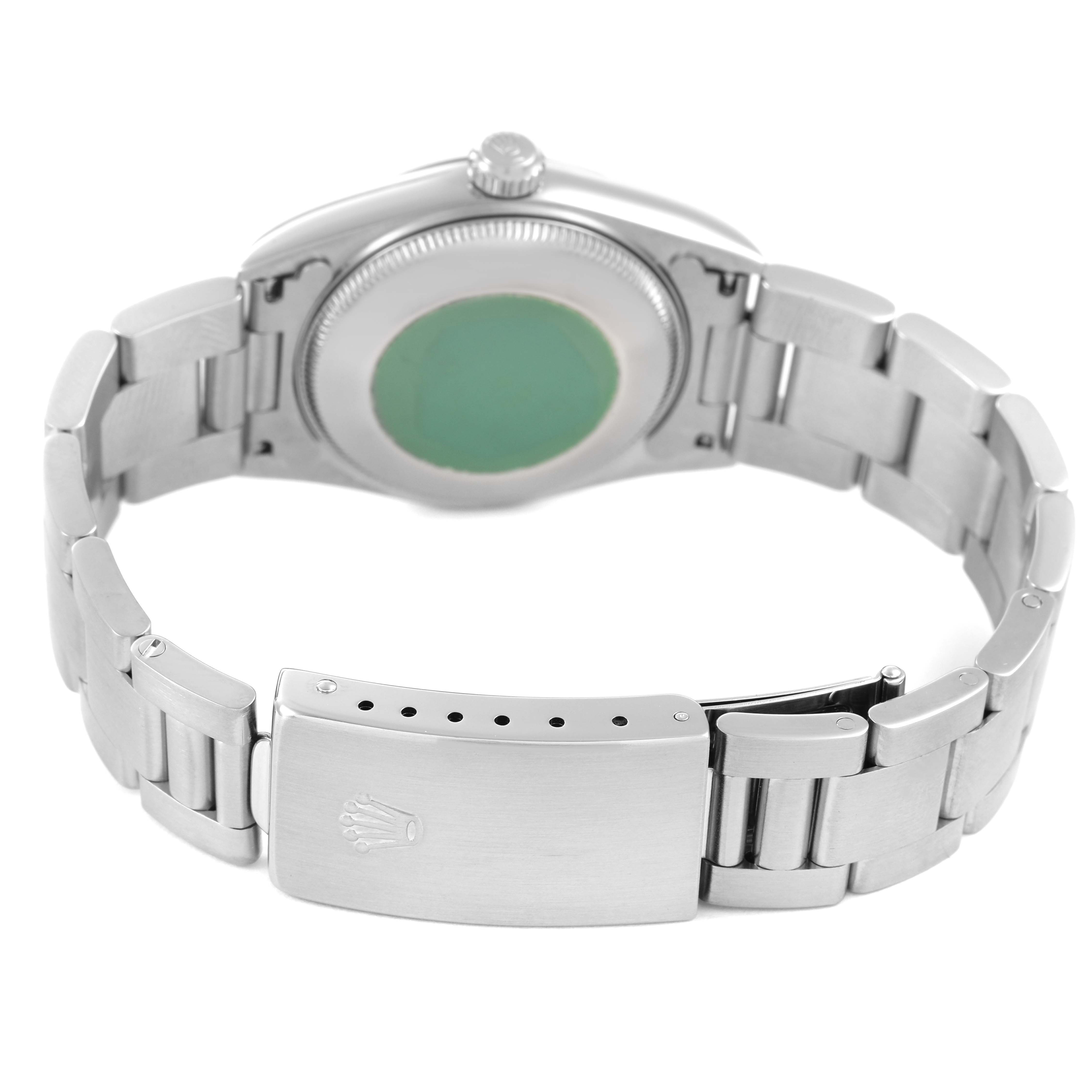 The Rolex Oyster Perpetual 77080 Women's Stainless Steel Blue Dial watch is shown from the back, highlighting the case, clasp, and bracelet links.