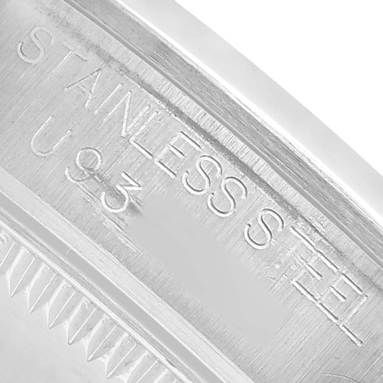 The angle shows a close-up of the edge of the stainless steel case of the Rolex Oyster Perpetual 67480 Women's Stainless Steel Pink Dial, featuring engraved text.