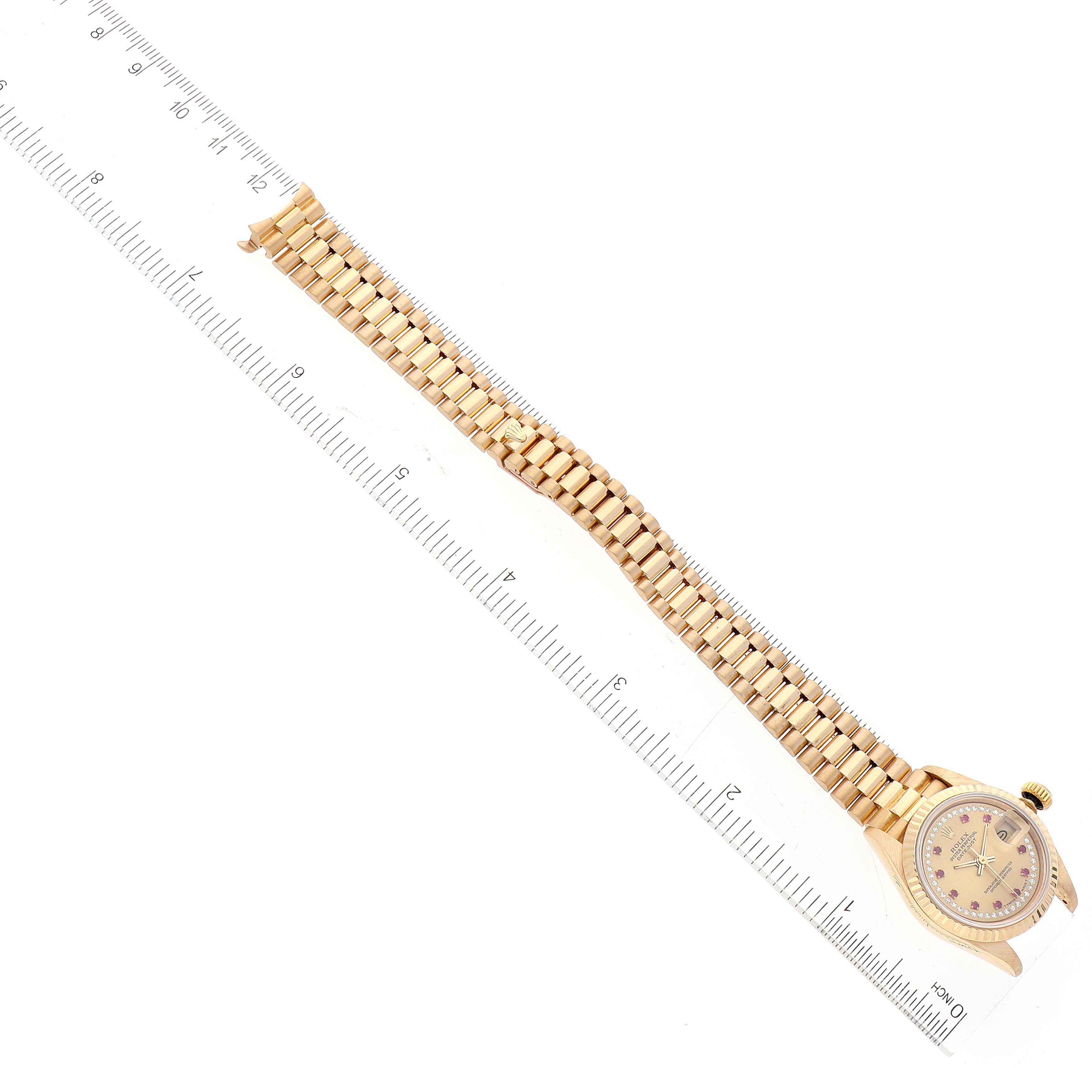 The image shows a top-down view of a Rolex President 69178 Women
s Yellow Gold Champagne Dial 69178 Women
s Yellow Gold Champagne Dial model watch, including the face, band, and a ruler for scale.