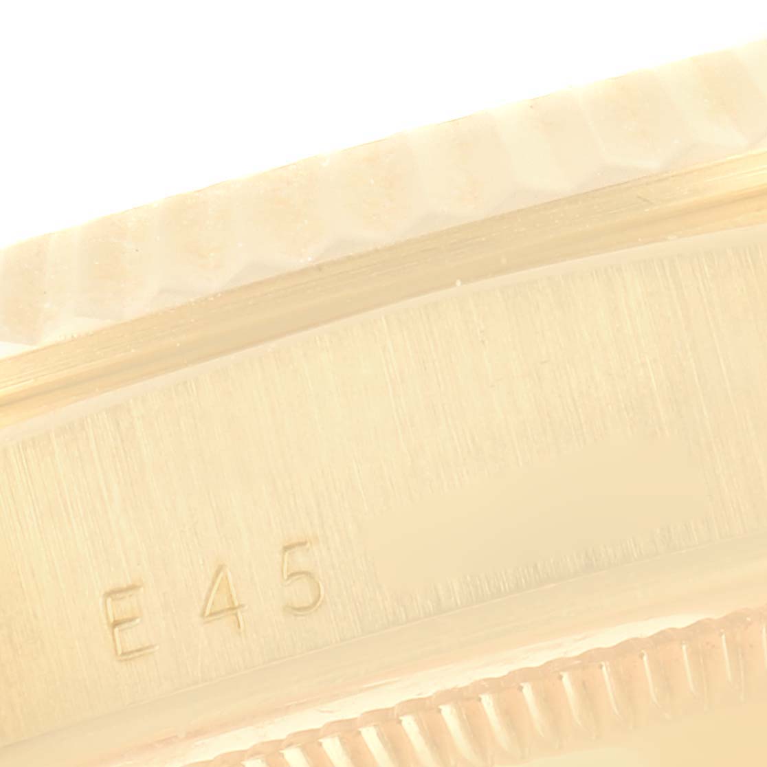 This close-up image shows the side of the bezel and part of the case with engraving on a Rolex President 18238 Men's Yellow Gold Champagne Dial 18238 Men's Yellow Gold Champagne Dial model watch.