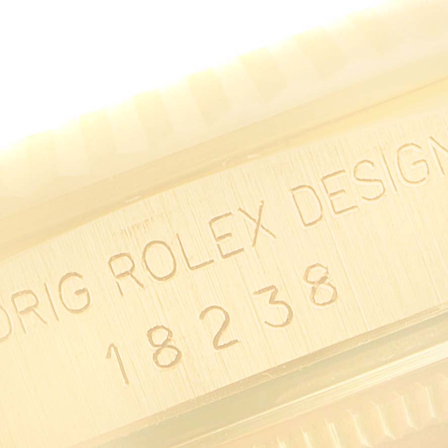 This close-up image of a Rolex President 18238 Men's Yellow Gold Champagne Dial 18238 Men's Yellow Gold Champagne Dial model 18238 shows part of the case with engraved text indicating the model number.