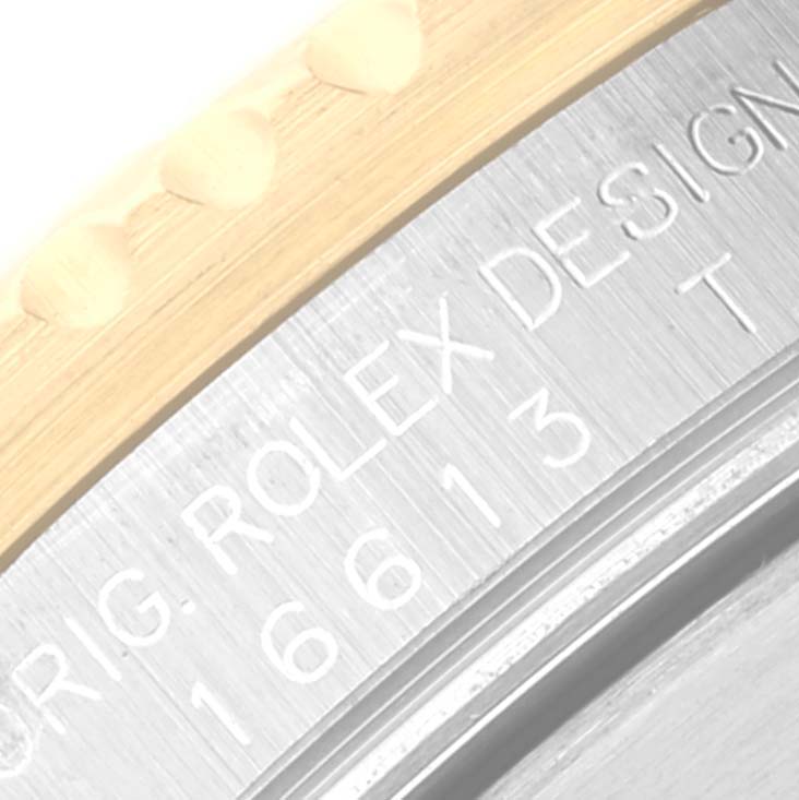 The image shows the side view of a Rolex Submariner 16613 Men's Steel and Gold (two tone) Blue Dial 16613 Men's Steel and Gold (two tone) Blue Dial, focusing on the bezel and engraved model details.