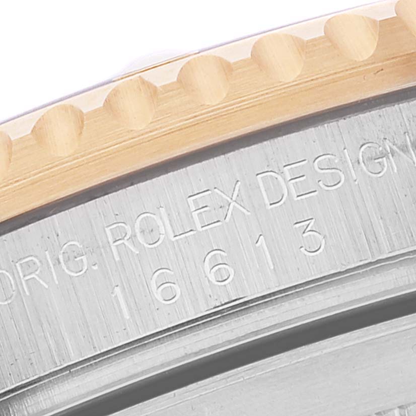 The image shows a close-up of the bezel and engraved case side of a Rolex Submariner 16613 Men
s Steel and Gold (two tone) Blue Dial 16613 Men
s Steel and Gold (two tone) Blue Dial watch.
