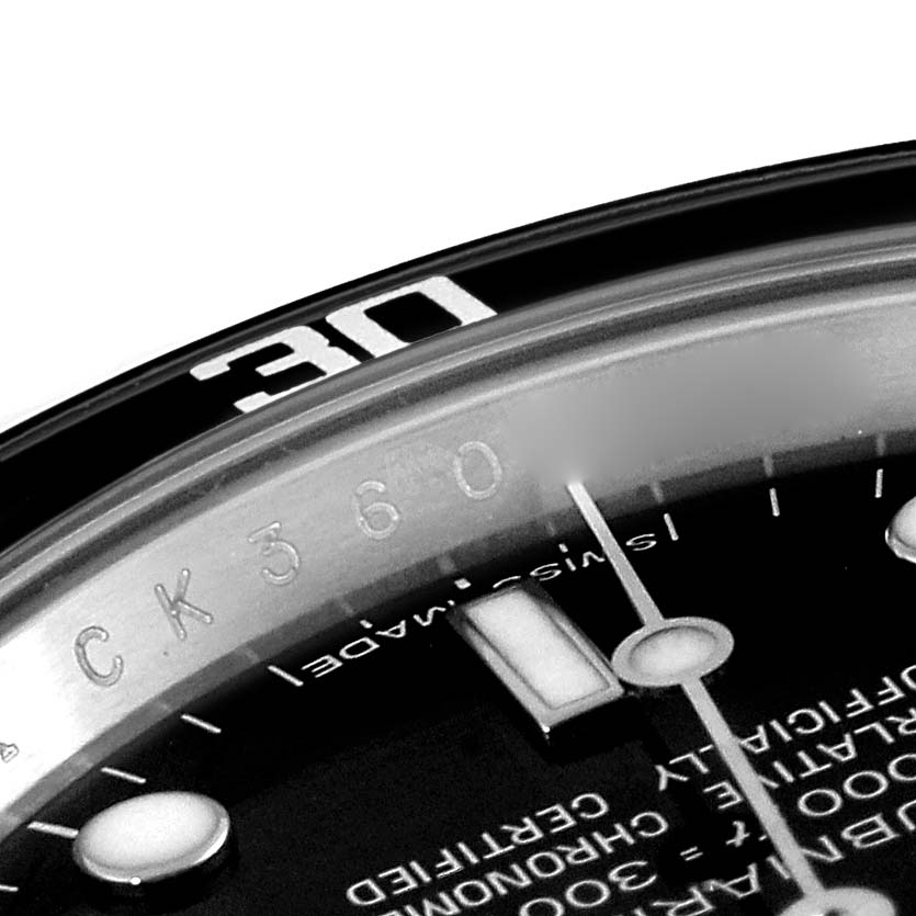 This close-up image of a Rolex Submariner 14060M Men's Stainless Steel Black Dial 14060M Men's Stainless Steel Black Dial watch shows the bezel, part of the dial, and the hands.