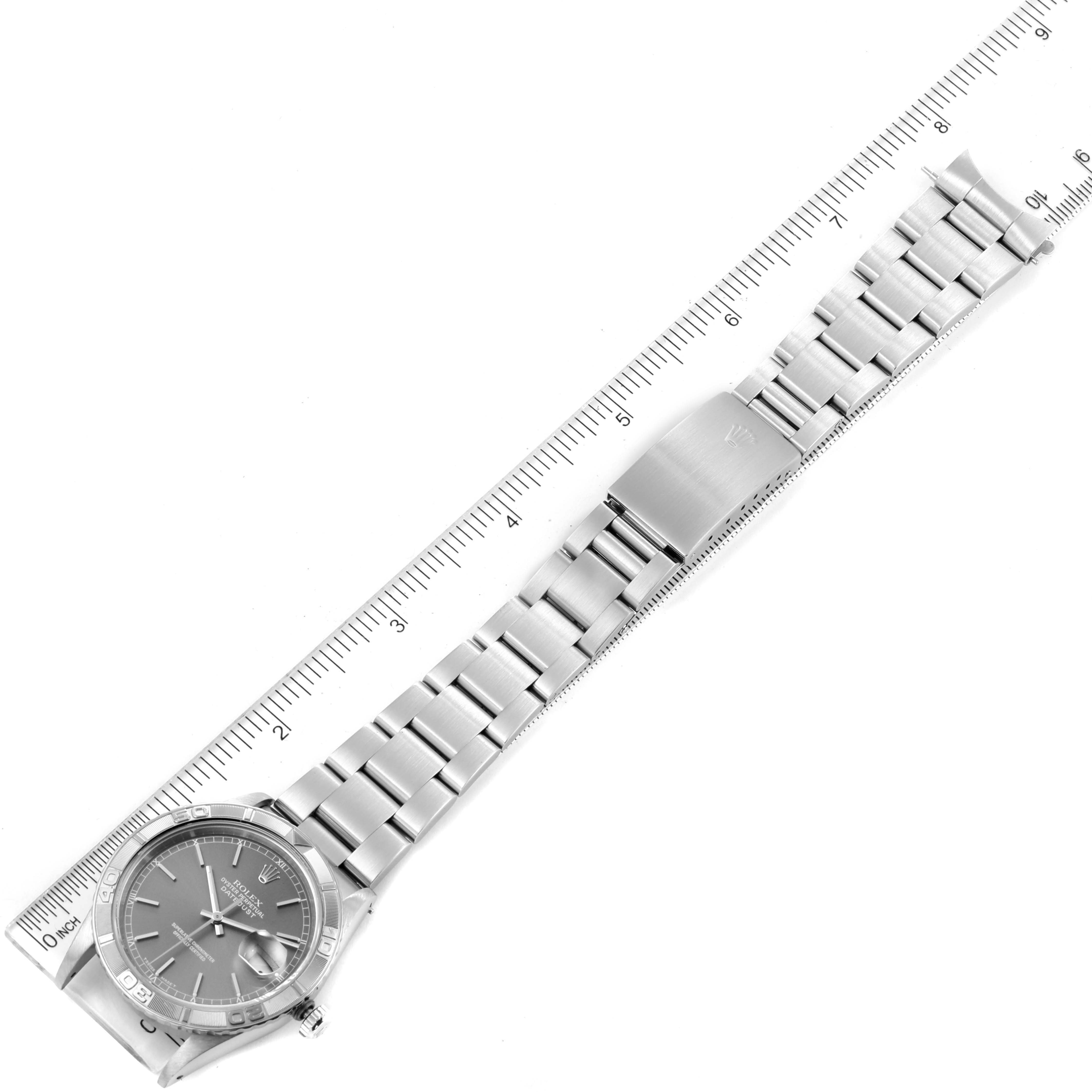The image shows a top-down view of a Rolex Turn-o-Graph 16264 Men's Stainless Steel Grey Dial 16264 Men's Stainless Steel Grey Dial watch, including its dial, bezel, bracelet, and clasp, alongside a ruler.