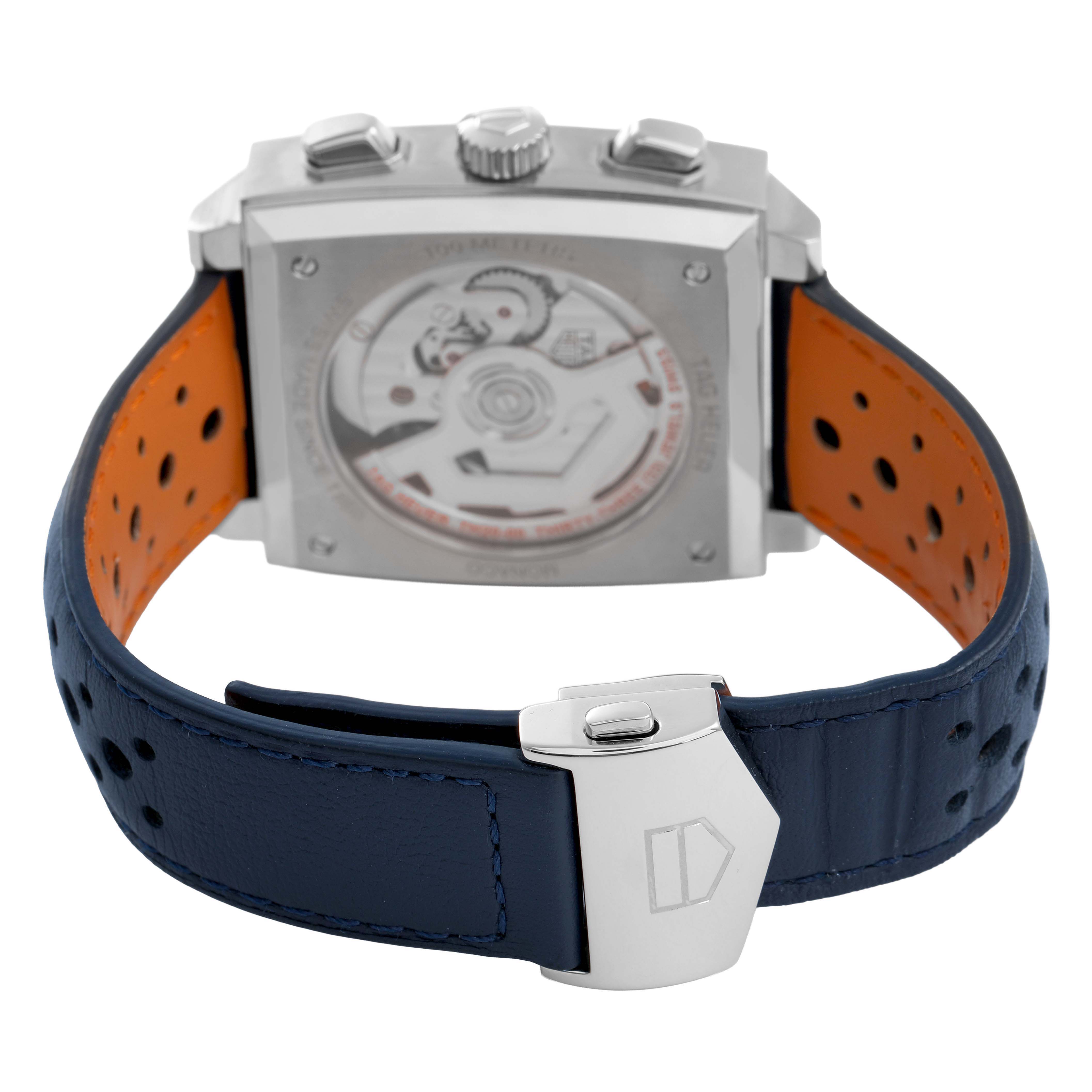 The image shows the back side of a Tag Heuer Monaco CBL2115 Men's Stainless Steel Blue Dial, highlighting the open case back, blue perforated strap, and clasp.