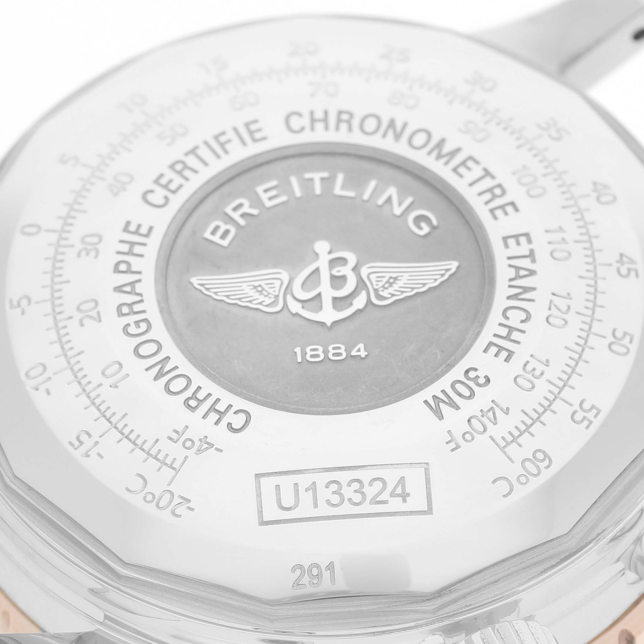 The image shows the back of a Breitling Navitimer U13324211B1X1 Men's Steel and Gold (two tone) Black Dial watch with engraved model details and branding.