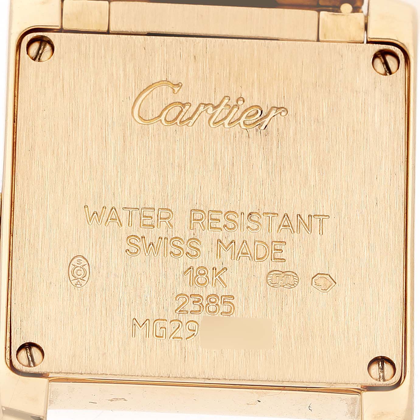 The image shows the back of a Cartier Tank Française watch, featuring engravings and the brand logo.