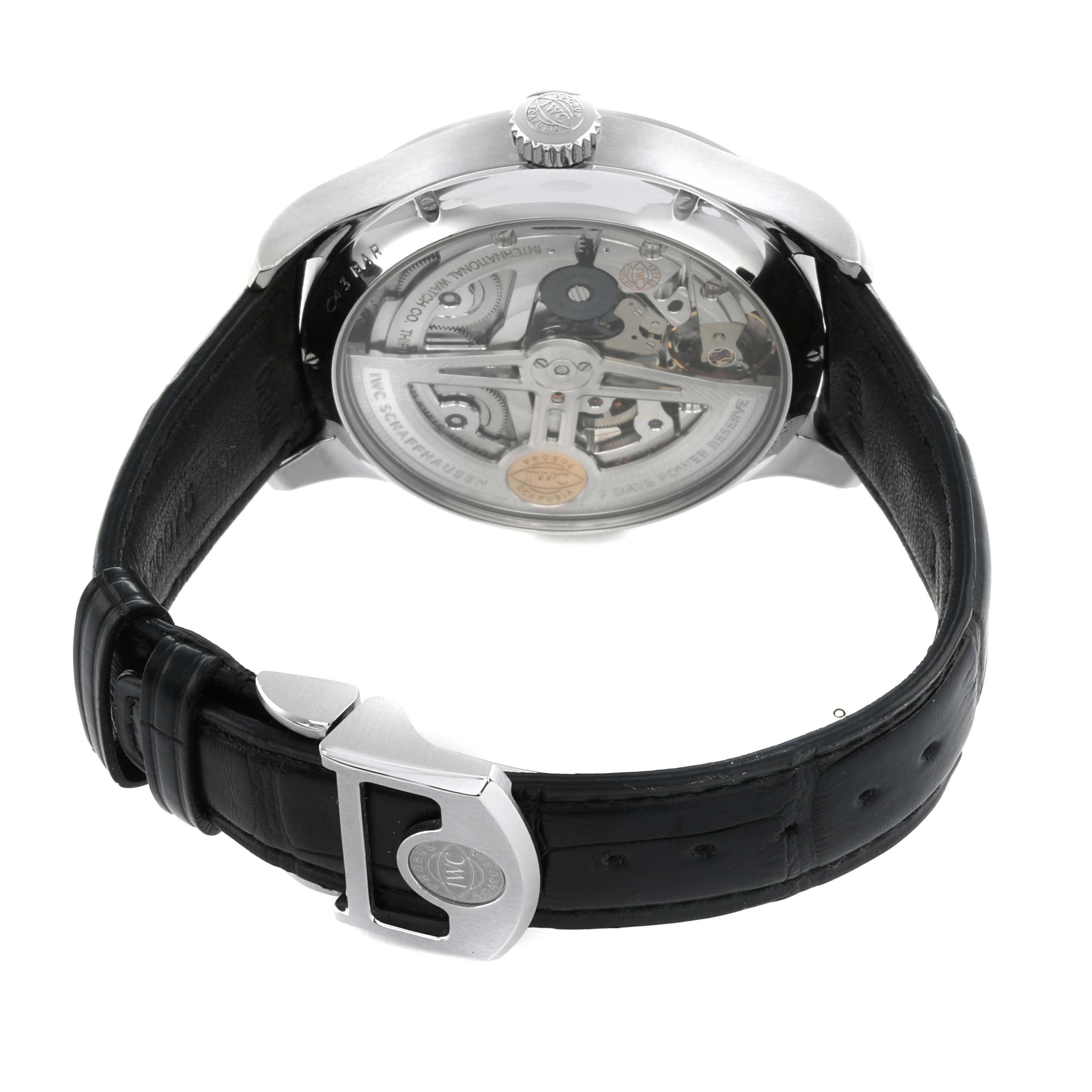 The IWC Portuguese IW503510 Men's Stainless Steel Green Dial watch is shown from the back, displaying the movement and rotor, with a leather strap and clasp visible.