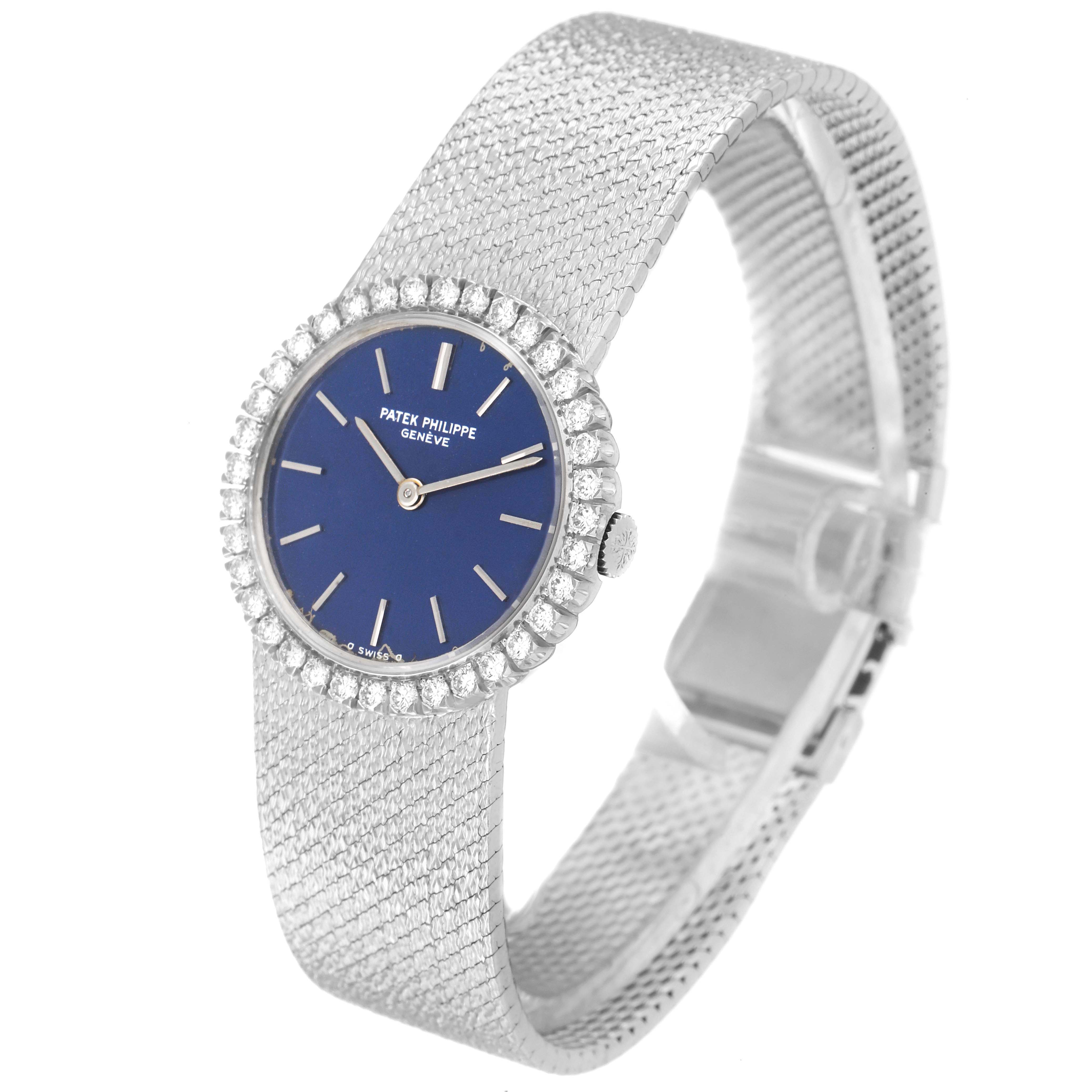 The image shows a side angle view of the Patek Philippe Calatrava 4182 Women's White Gold Blue Dial 4182 Women's White Gold Blue Dial watch highlighting the blue dial, diamond bezel, and metal mesh strap.