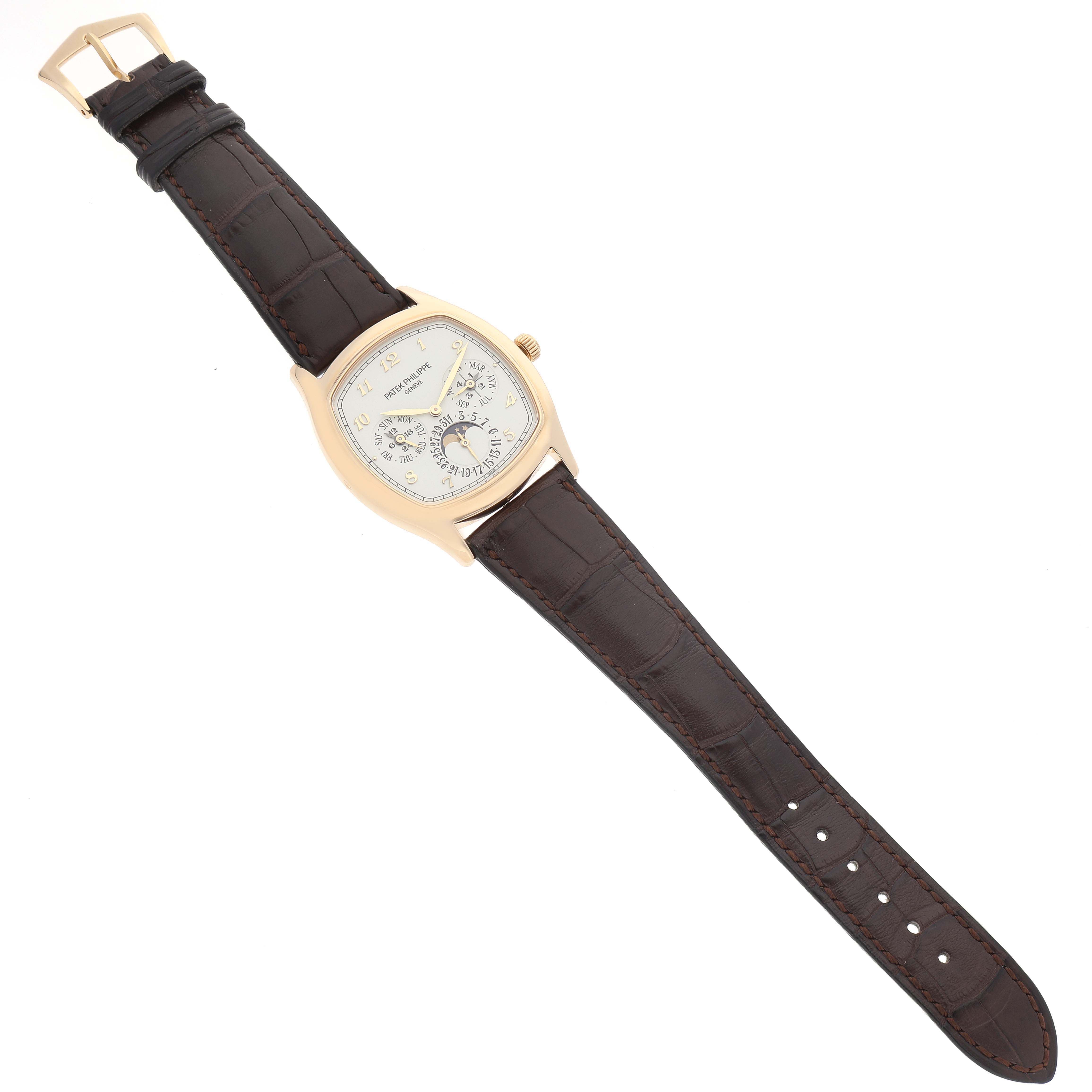 The image shows a Patek Philippe Complications 5940J - 001 Men's Yellow Gold Silver Dial 5940J - 001 Men's Yellow Gold Silver Dial watch from a top-down perspective, displaying the entire strap and face.