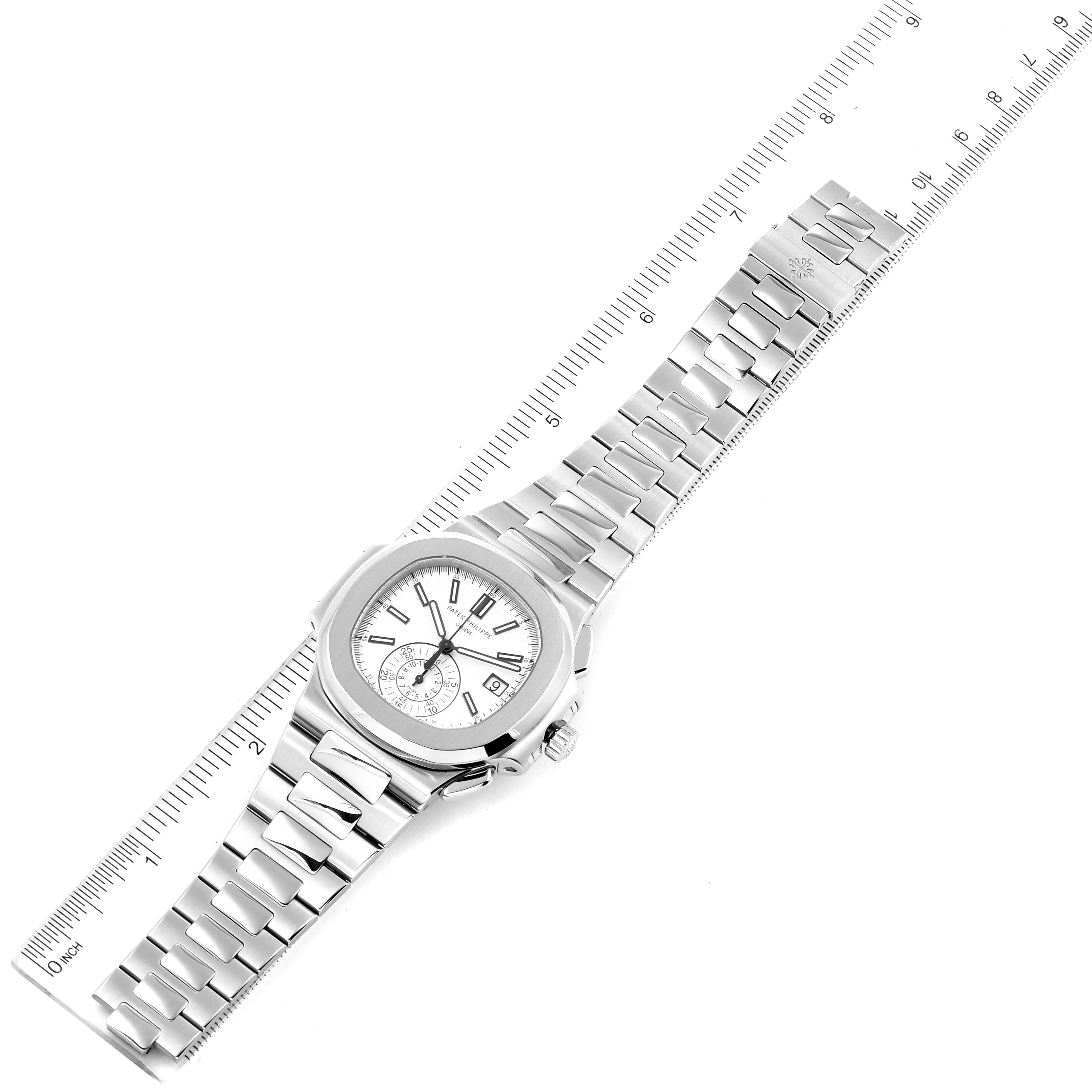 This image shows a top view of the Patek Philippe Nautilus 5980/1A Men's Stainless Steel White Dial 5980/1A Men's Stainless Steel White Dial watch, displaying its face, bracelet, and crown along with a measuring scale.