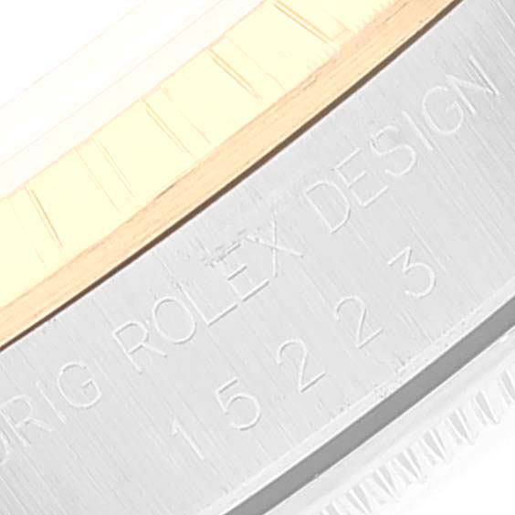 This image shows a close-up of the side engraving and part of the bezel of a Rolex Date 15223 Men's Steel and Gold (two tone) White Dial 15223 Men's Steel and Gold (two tone) White Dial model watch.
