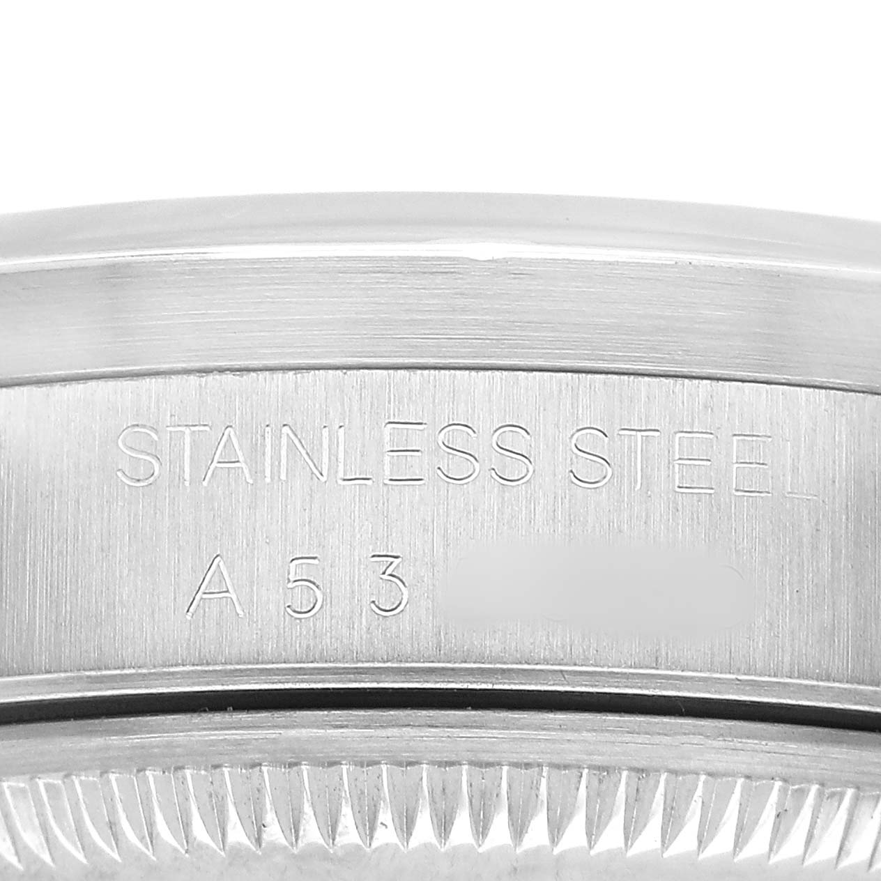 The image shows a close-up of the stainless steel casing edge and engraved text on the Rolex Date 15210 Men's Stainless Steel White Dial watch.