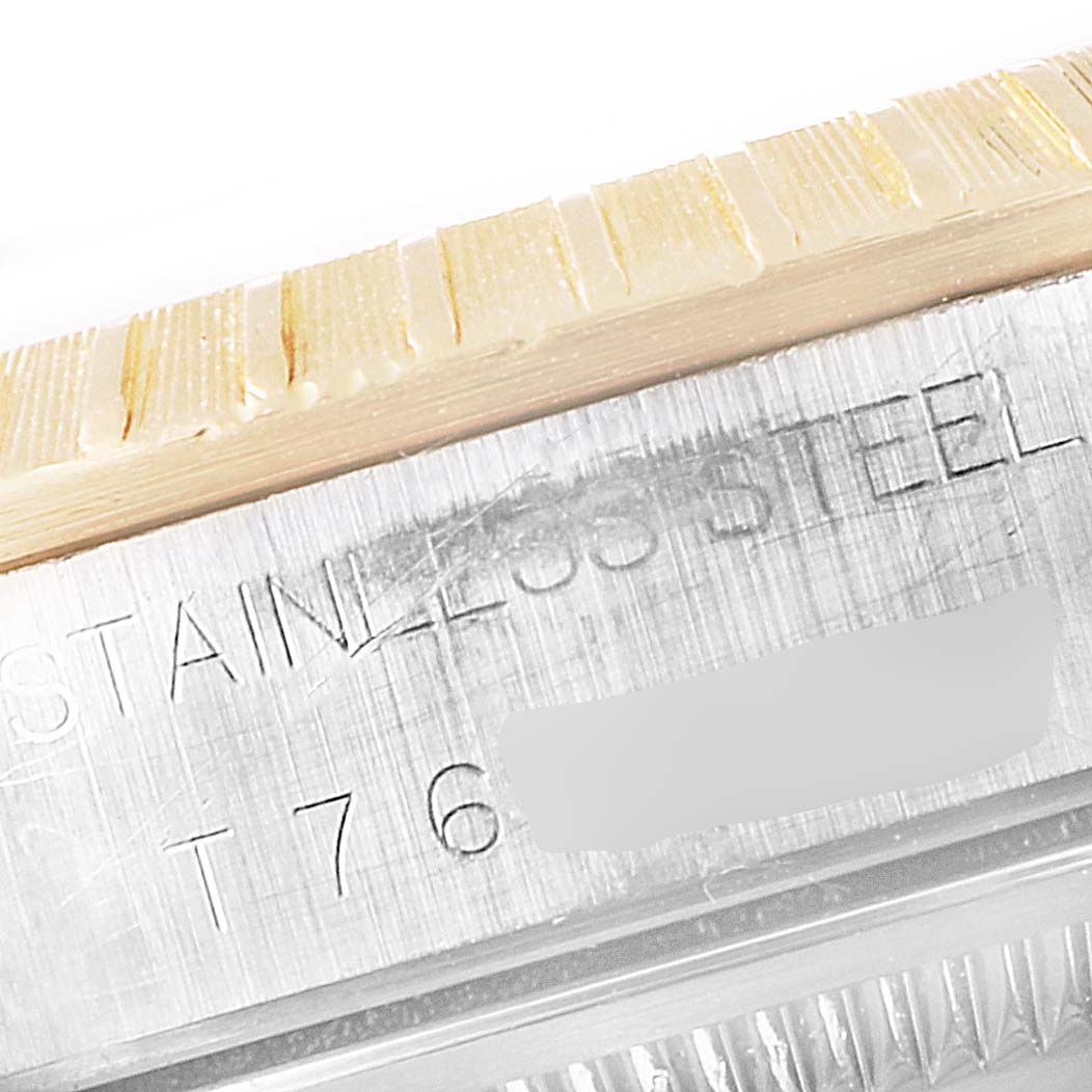 Close-up of the side of a Rolex Datejust 15223 Men's Steel and Gold (two tone) Blue Dial 15223 Men's Steel and Gold (two tone) Blue Dial watch showing the stainless steel casing and part of the bezel engravings.