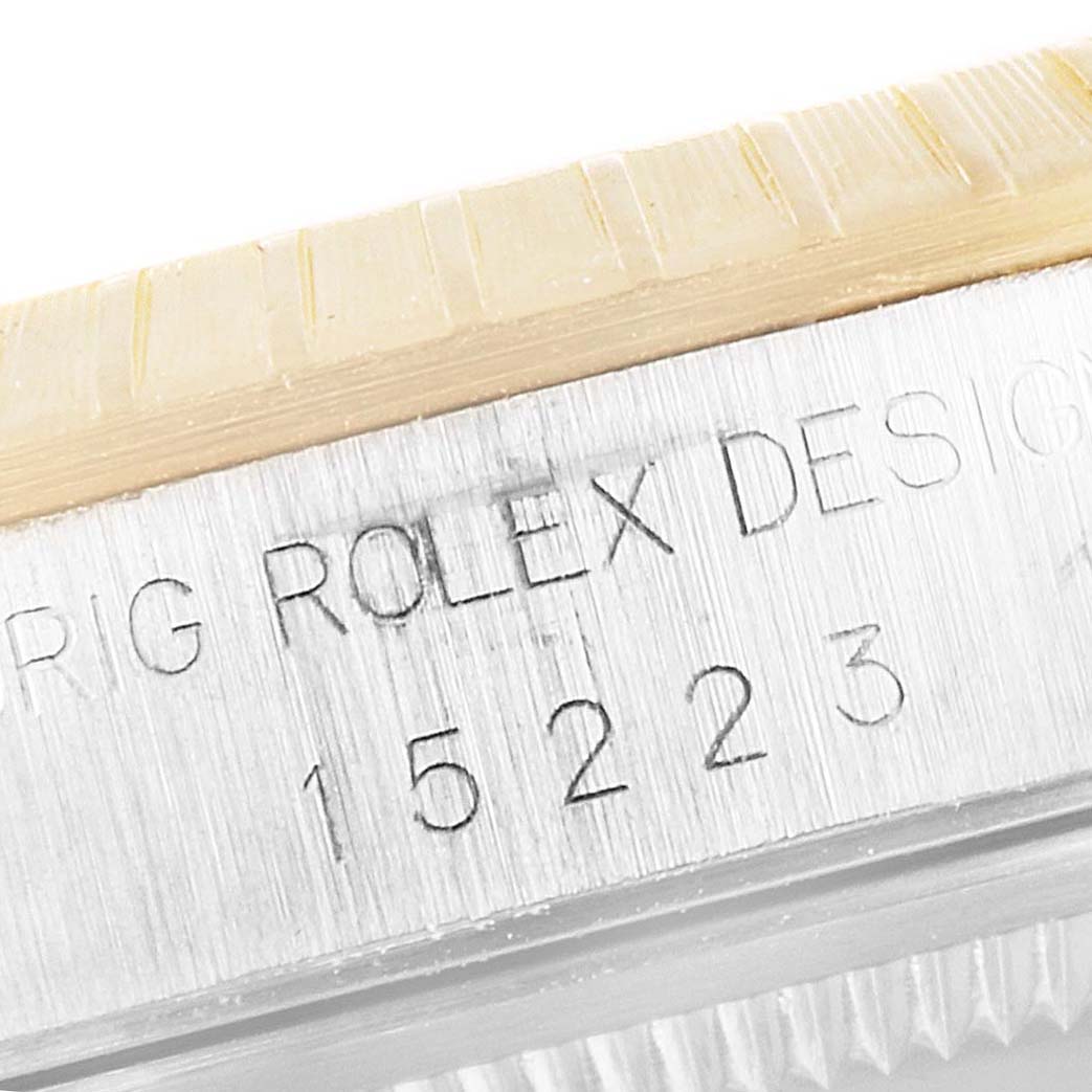 Close-up showing the serial number and the "Rolex Design" engraving on the case of a Rolex Datejust 15223 Men's Steel and Gold (two tone) Blue Dial 15223 Men's Steel and Gold (two tone) Blue Dial watch.