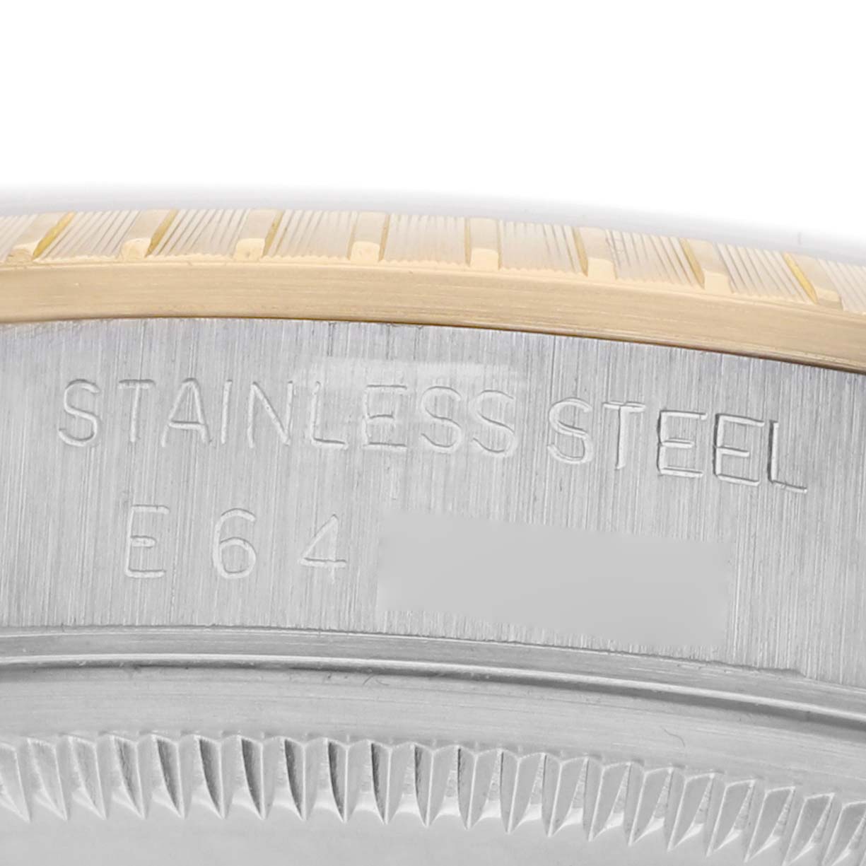 The image shows a close-up of the side engraving on a Rolex Date 15223 Men's Steel and Gold (two tone) Champagne Dial watch, highlighting the "STAINLESS STEEL" marking.