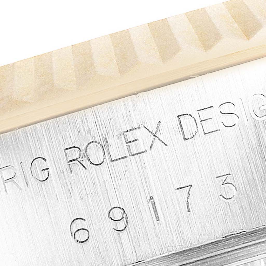 This image shows a close-up of the Rolex Datejust 69173 Women's Steel and Gold (two tone) Champagne Dial 69173 Women's Steel and Gold (two tone) Champagne Dial model's bezel and engraved casing serial number.
