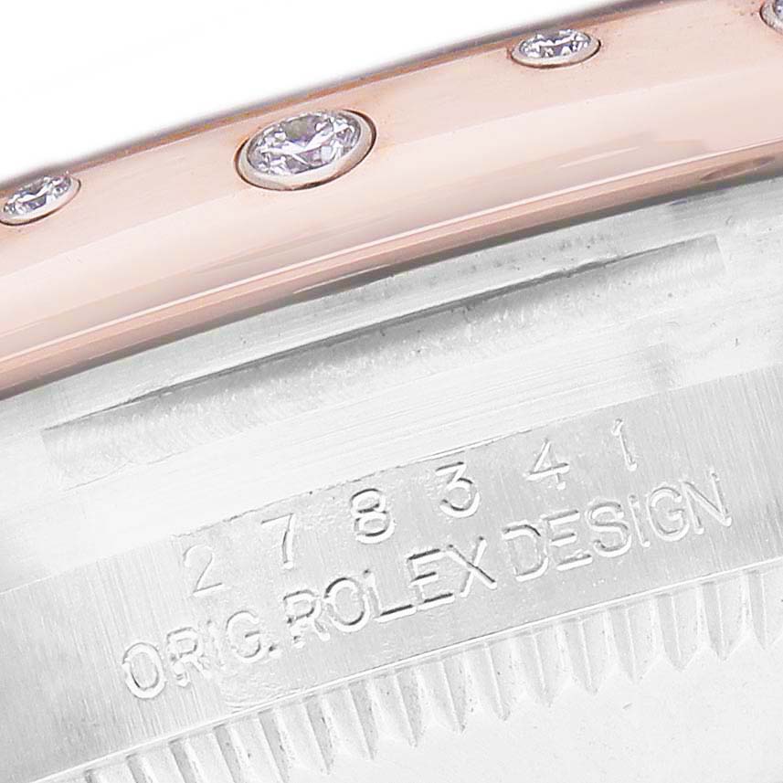 The image shows a close-up of a Rolex Datejust Women's Steel and Gold (two tone) Pink Dial bezel and part of the case with engraved details.