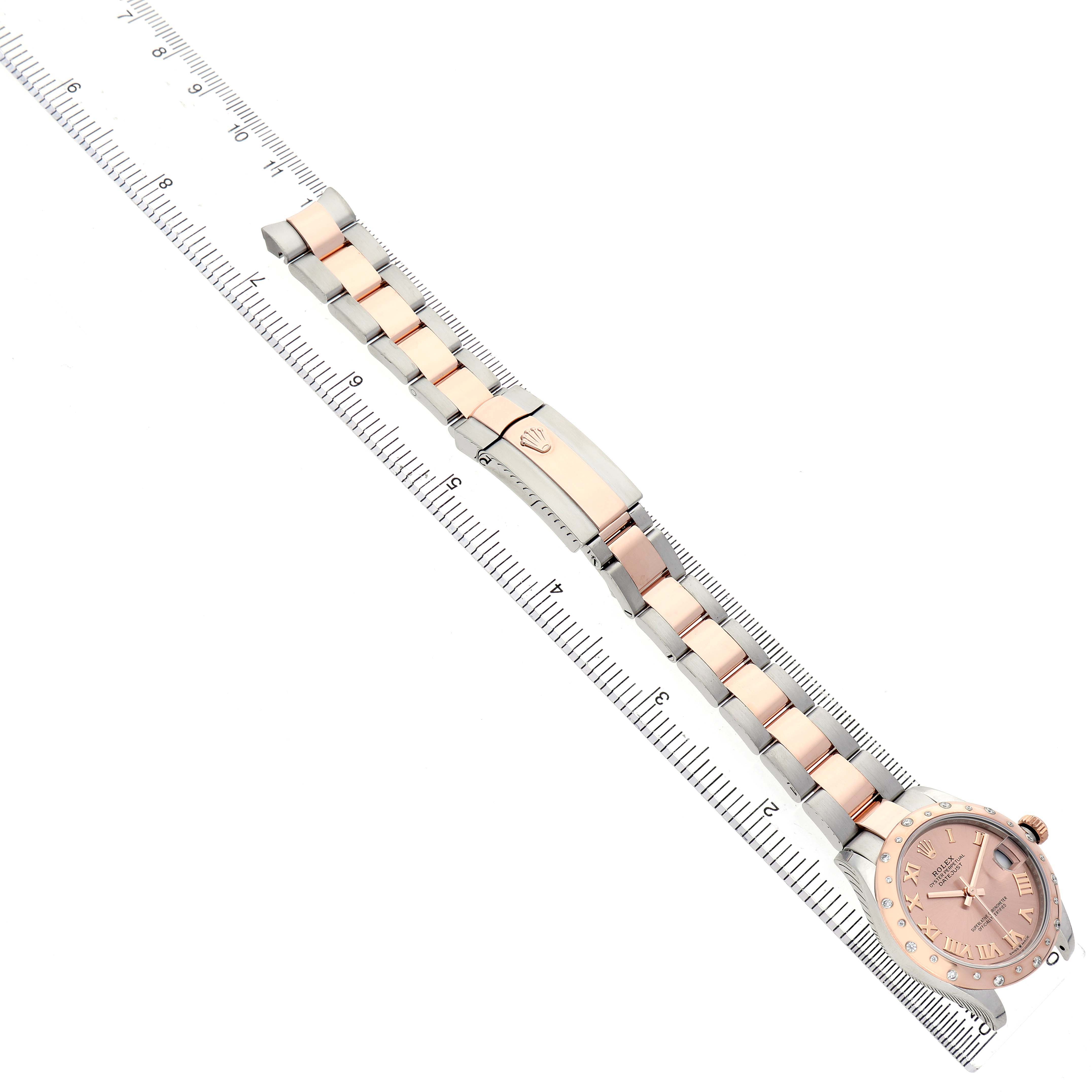 The Rolex Datejust Women's Steel and Gold (two tone) Pink Dial watch is shown from an overhead angle, displaying the bracelet, clasp, and dial.