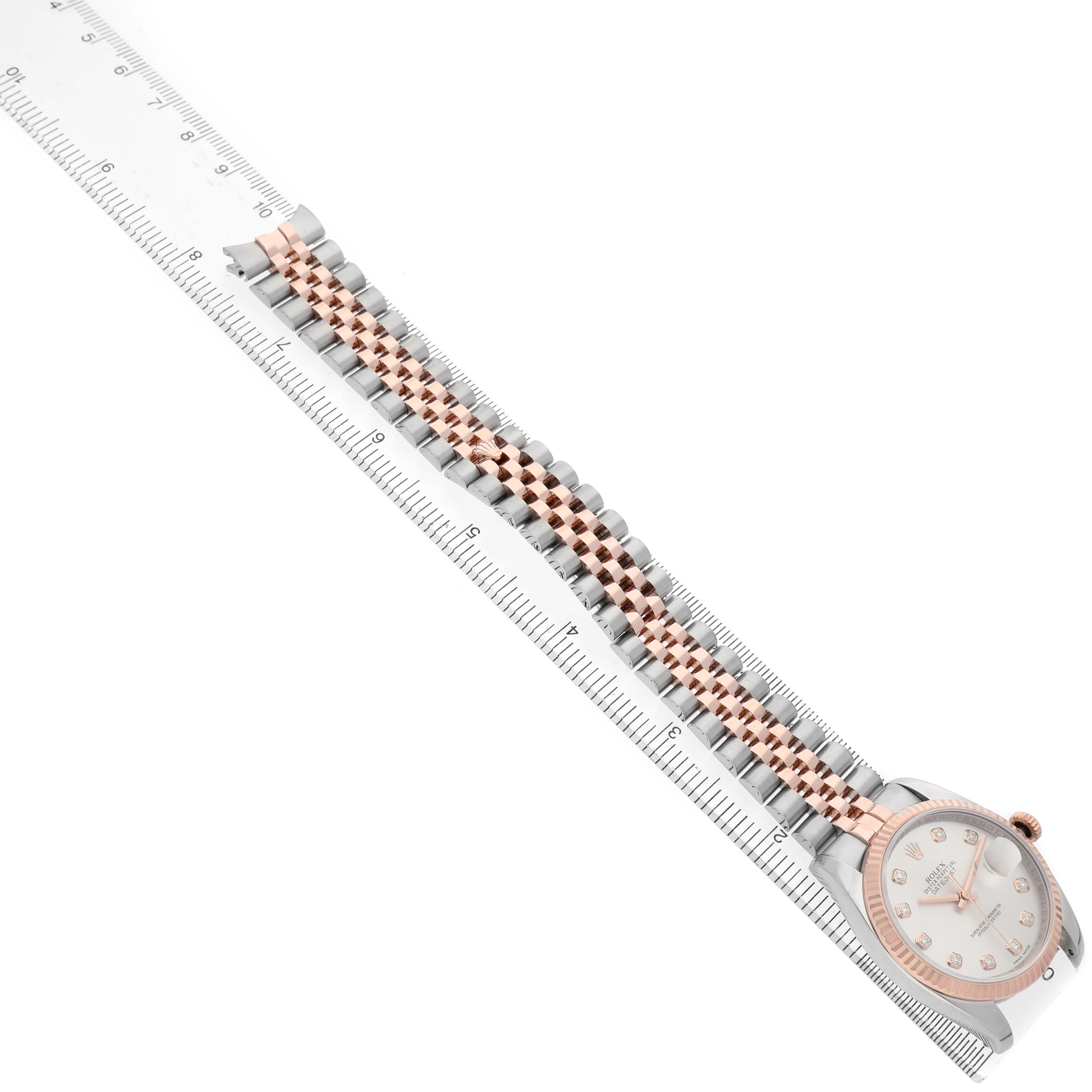 The Rolex Datejust 116231 Men's Steel and Gold (two tone) Silver Dial watch is shown at an angled view with the case, dial, and full bracelet visible, alongside a ruler for scale.