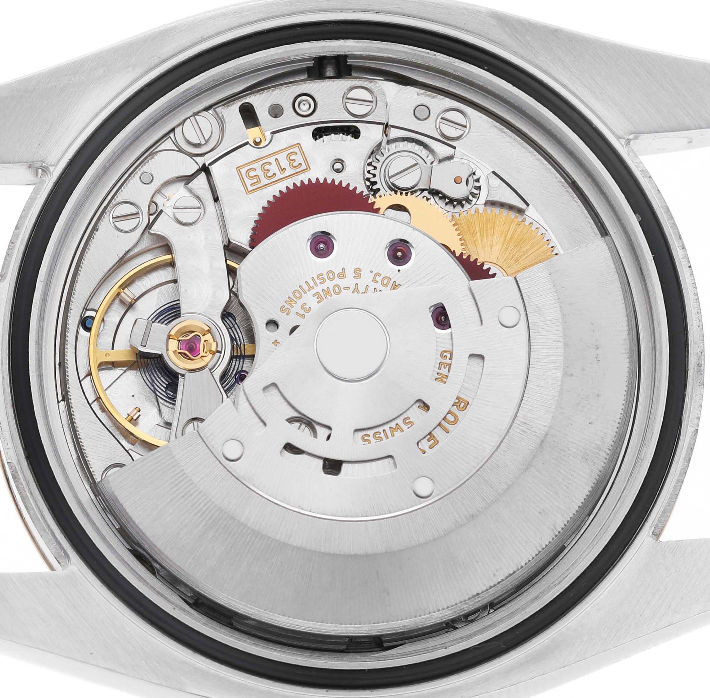 The image shows the movement mechanism of a Rolex Datejust 116203 Men's Steel and Gold (two tone) Silver Dial, view from the back, revealing gears and inscriptions.