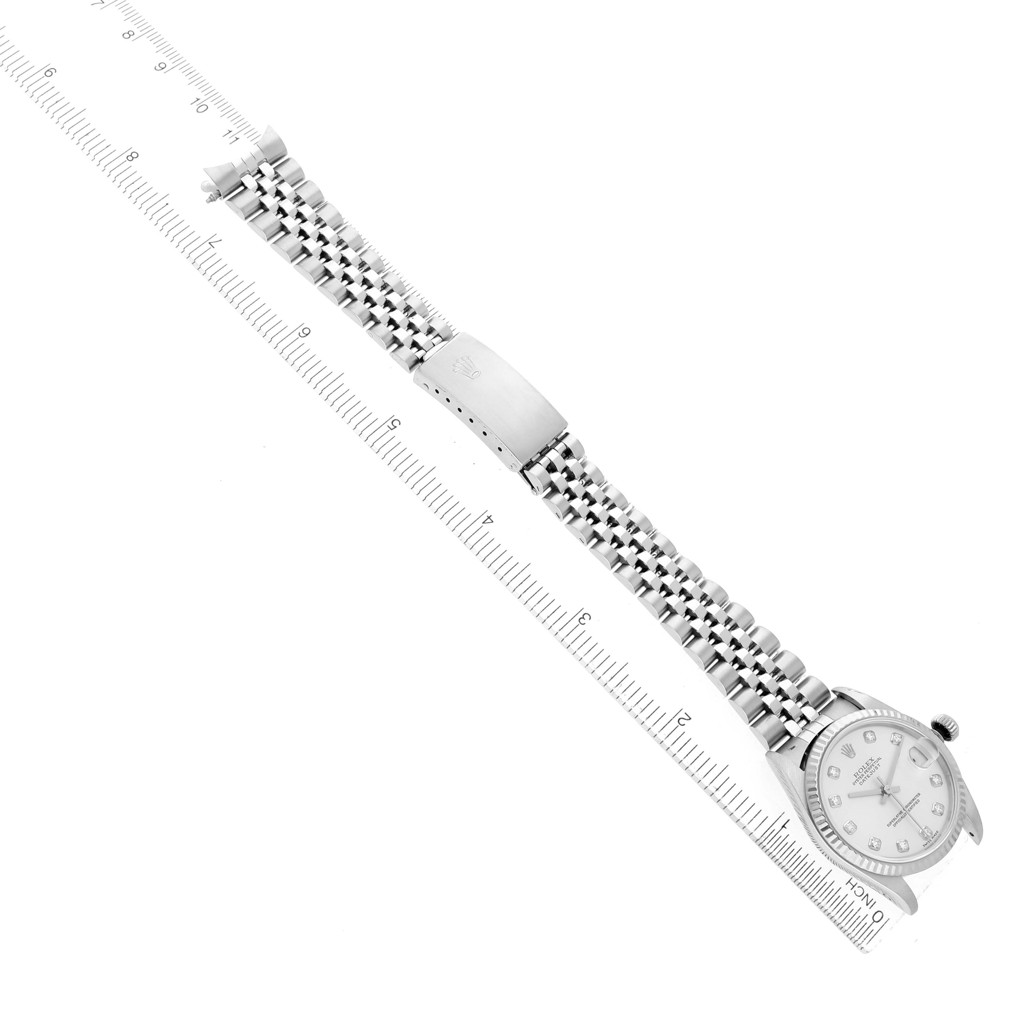 The Rolex Datejust 78274 Women's Stainless Steel Silver Dial watch is displayed from a top-down angle, showing the face, bracelet, and clasp alongside a ruler for scale.