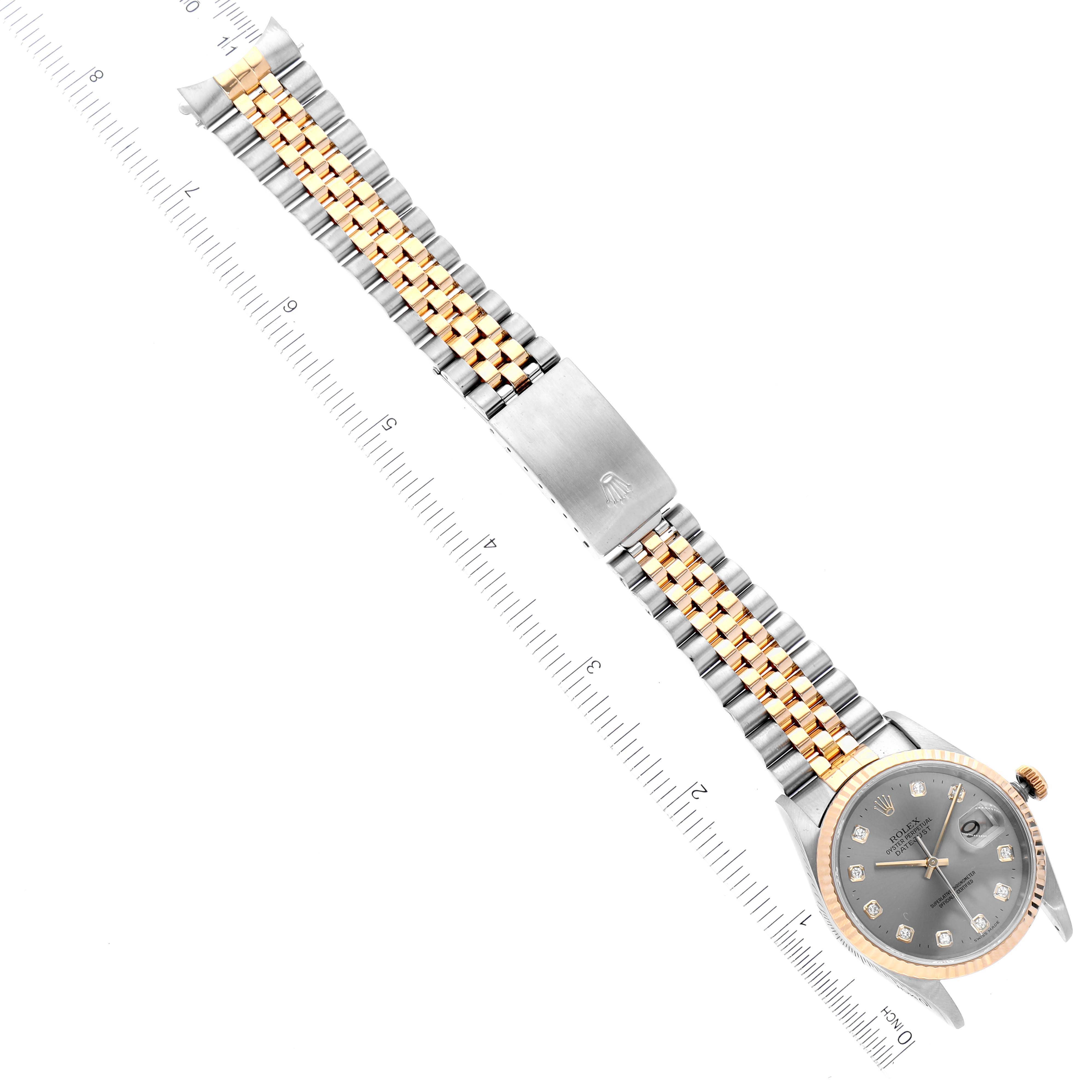 The image shows a full view of the Rolex Datejust 16233 Men
s Steel and Gold (two tone) Grey Dial 16233 Men
s Steel and Gold (two tone) Grey Dial watch laid flat, emphasizing the two-tone bracelet and face, with a ruler along its length.
