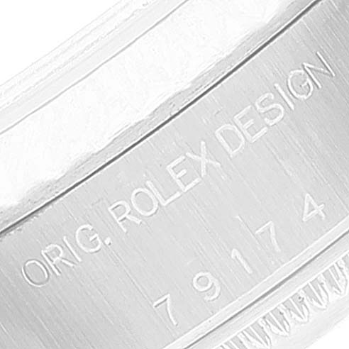 The image shows a close-up of the engraved bezel of a Rolex Datejust 79174 Women's Stainless Steel Silver Dial 79174 Women's Stainless Steel Silver Dial watch, highlighting the "Orig. Rolex Design" inscription and serial number.