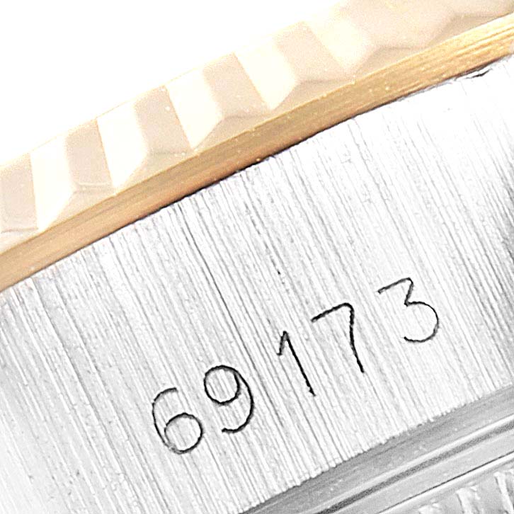 The image shows a close-up of the engraved case and fluted bezel of a Rolex Datejust 69173 Women's Steel and Gold (two tone) Champagne Dial 69173 Women's Steel and Gold (two tone) Champagne Dial watch.