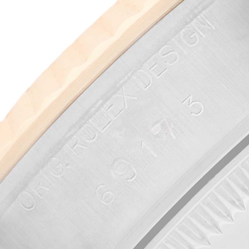 The image shows a close-up of the side edge of a Rolex Datejust 69173 Women's Steel and Gold (two tone) Champagne Dial watch, focusing on the engraved details and part of the bezel.