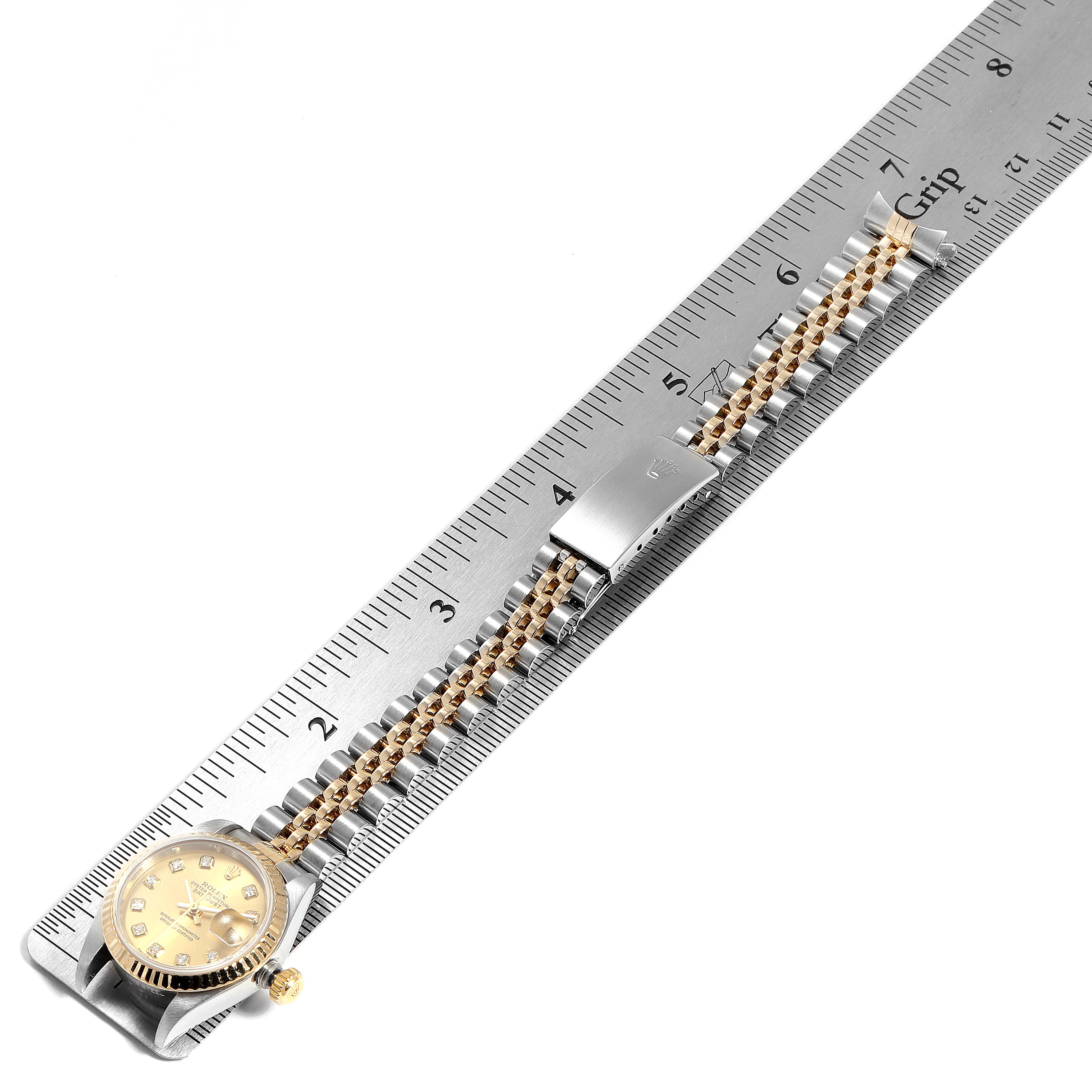 The Rolex Datejust 79173 Women's Stainless Steel Champagne Dial 79173 Women's Stainless Steel Champagne Dial watch is laid flat with its bracelet extended, aligned against a ruler for measurement.