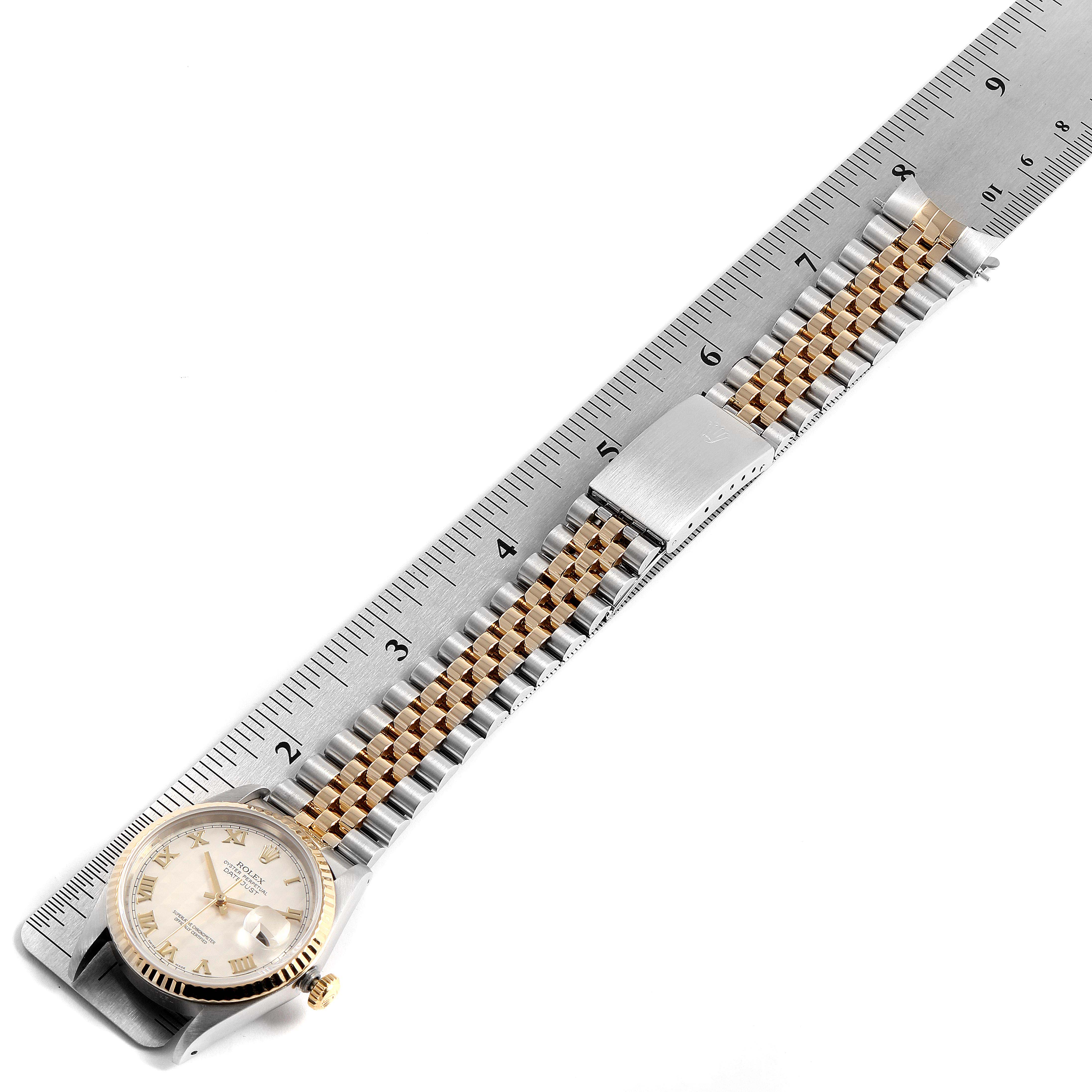 The image shows a Rolex Datejust 16233 Men
s Steel and Gold (two tone) Silver Dial 16233 Men
s Steel and Gold (two tone) Silver Dial watch laid flat with its bracelet next to a ruler for measurement.