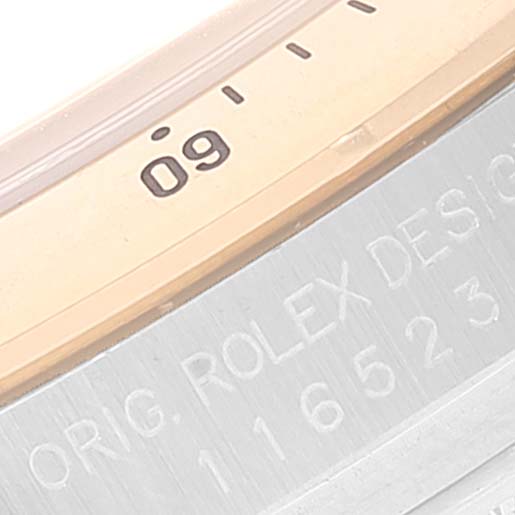 This image shows a close-up of the bezel and part of the engraving on a Rolex Daytona 116523 Men's Steel and Gold (two tone) Black Dial 116523 Men's Steel and Gold (two tone) Black Dial watch.