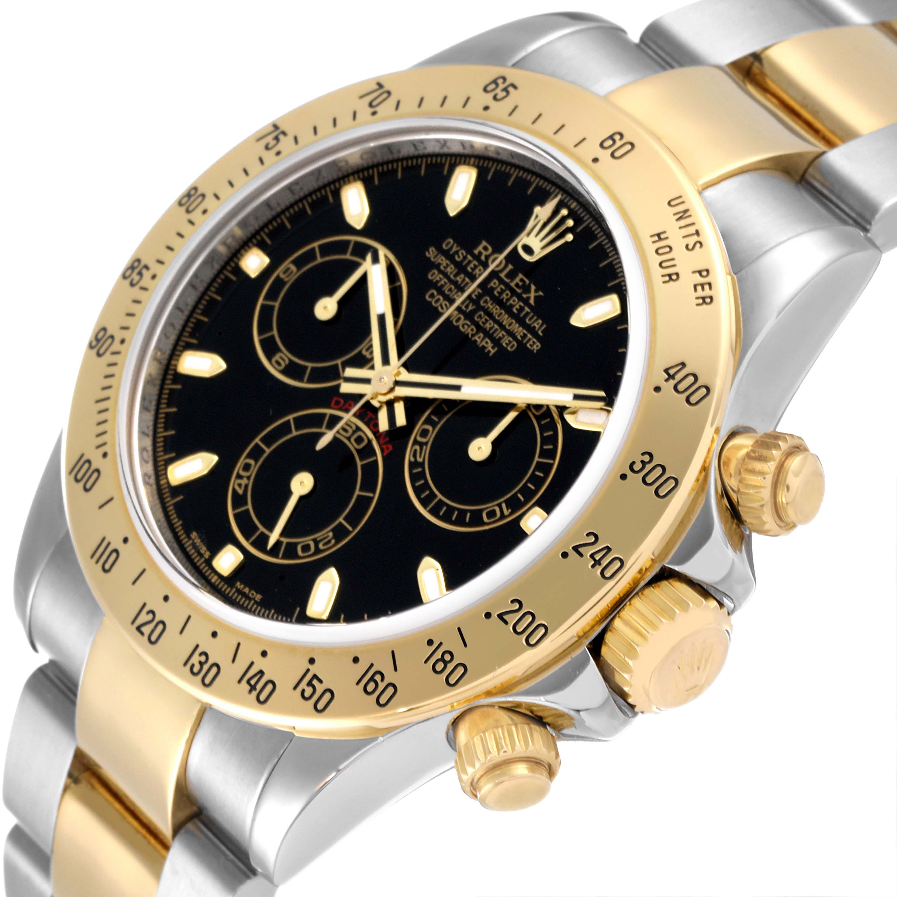The image shows a close-up angle of the Rolex Daytona 116523 Men's Steel and Gold (two tone) Black Dial 116523 Men's Steel and Gold (two tone) Black Dial watch, highlighting its black dial, gold subdials, and two-tone bracelet.