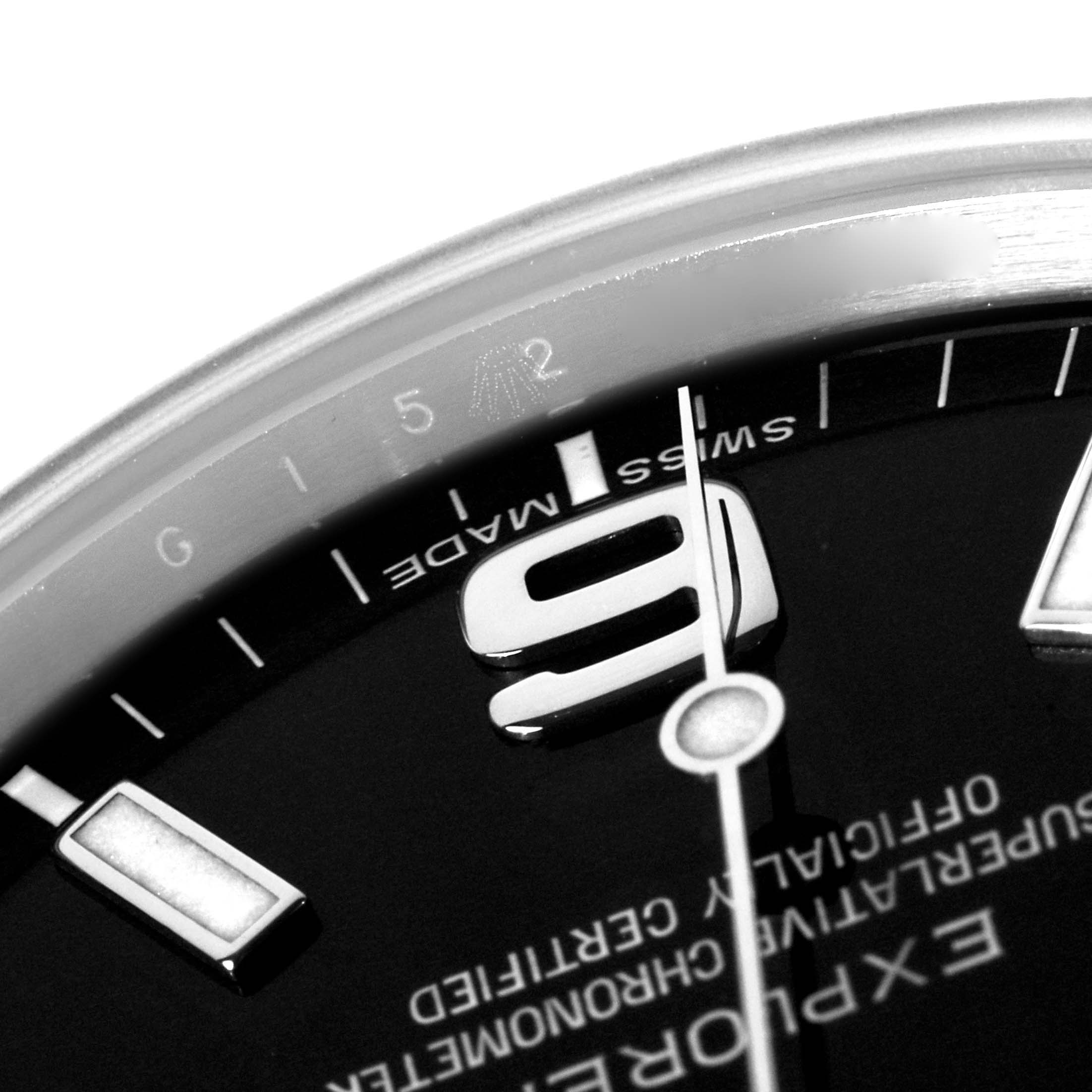 The image shows a close-up of the Rolex Explorer 214270 Men's Stainless Steel Black Dial watch face, highlighting the numeral "9", minute markers, and watch hands at an angle.