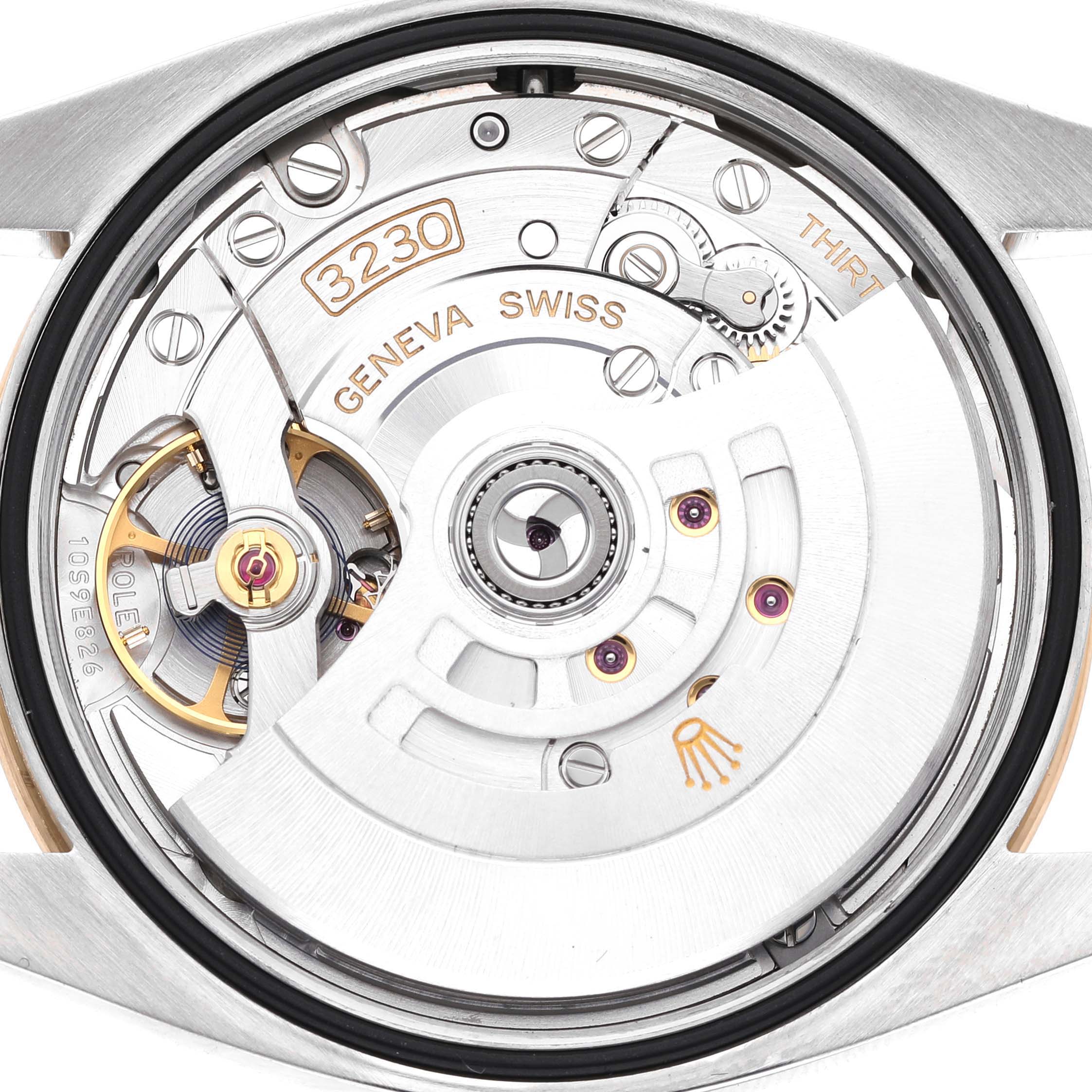 The image shows the movement of a Rolex Explorer 124273 Men's Steel and Gold (two tone) Black Dial watch, viewed from the back with visible gears and inscriptions.