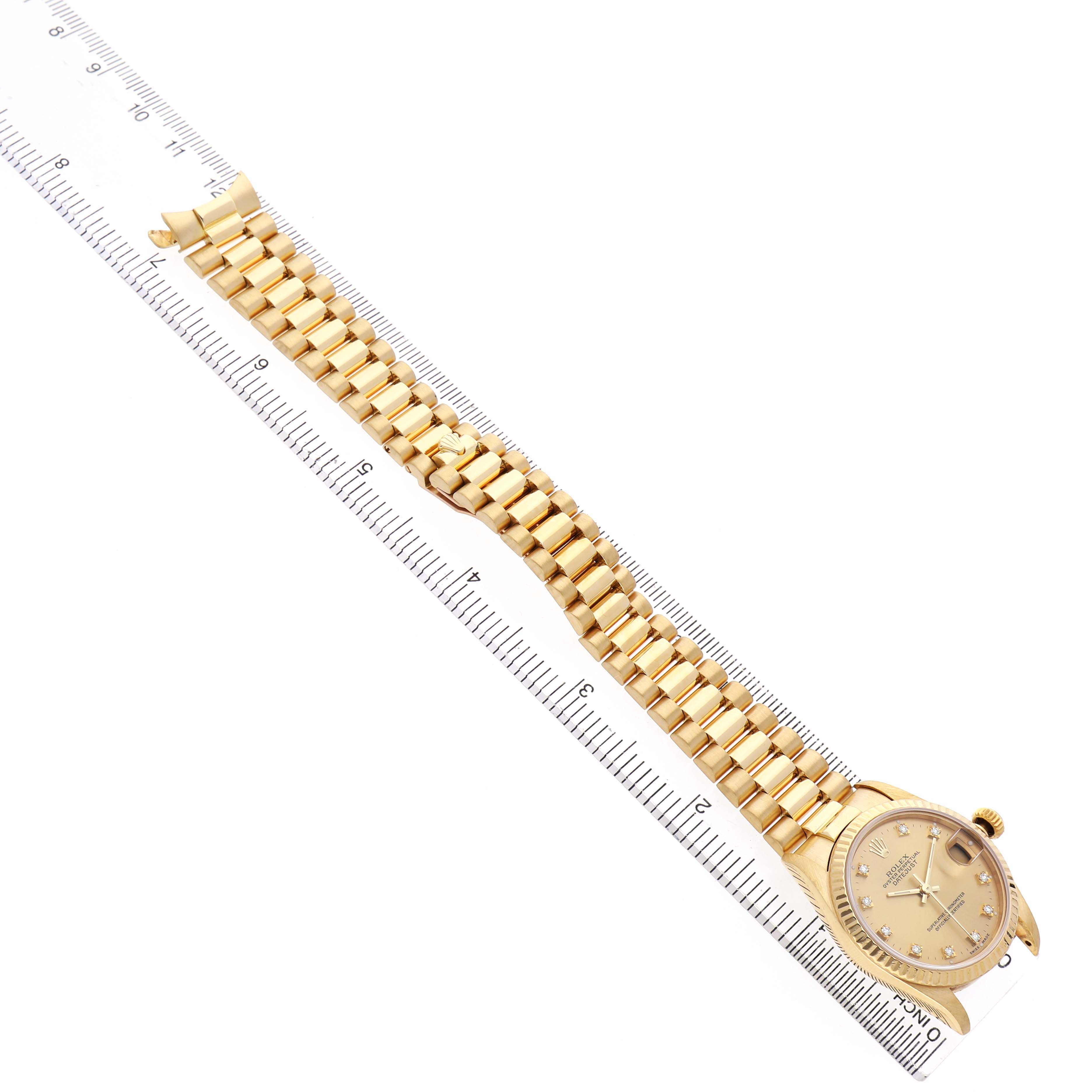 The Rolex President 68278 Women's Yellow Gold Champagne Dial watch is shown diagonally with the dial and full bracelet visible, alongside a ruler for scale.