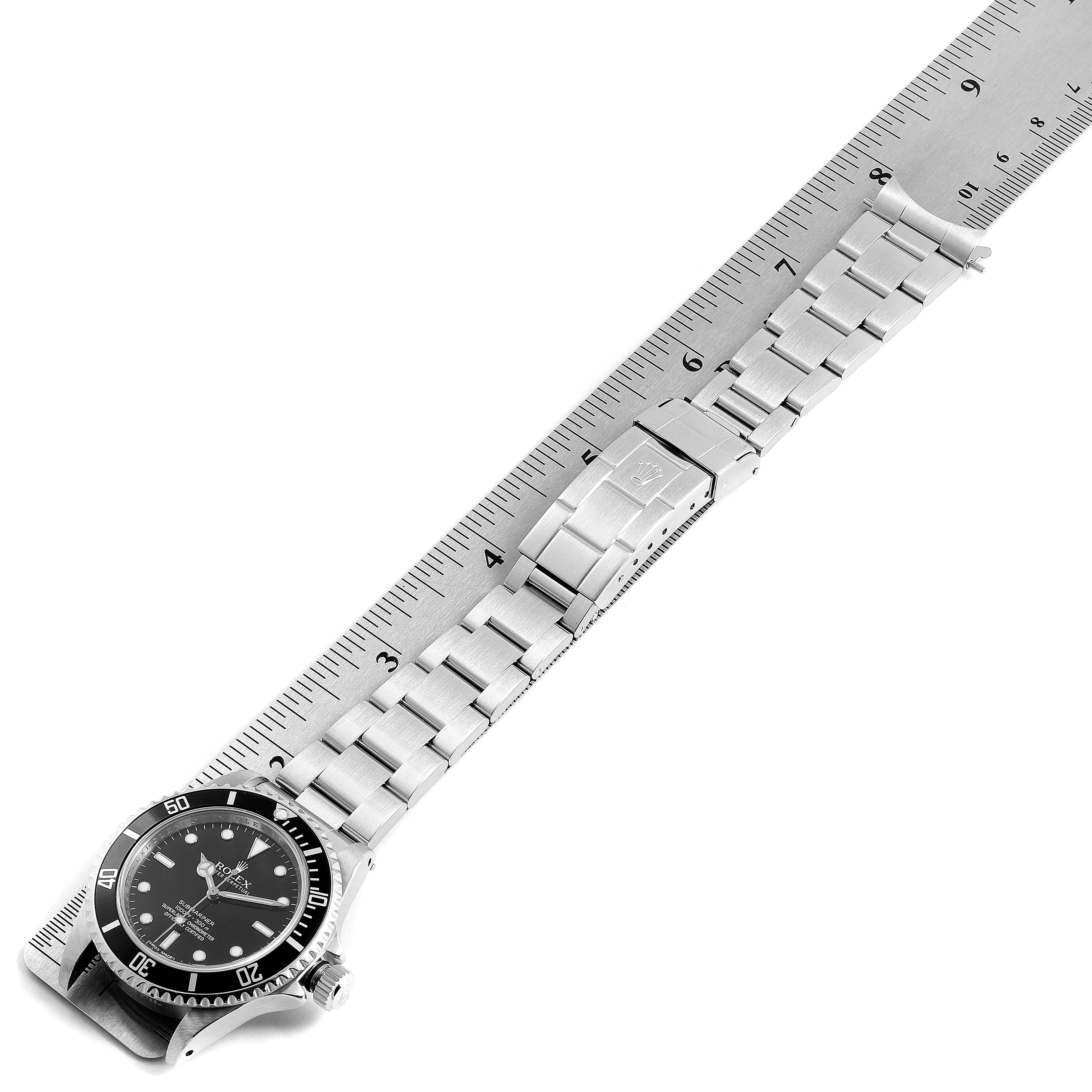 The image shows a Rolex Submariner 14060 Men's Stainless Steel Black Dial 14060 Men's Stainless Steel Black Dial watch laid flat against a ruler, showcasing the face, bezel, metal bracelet, and clasp.