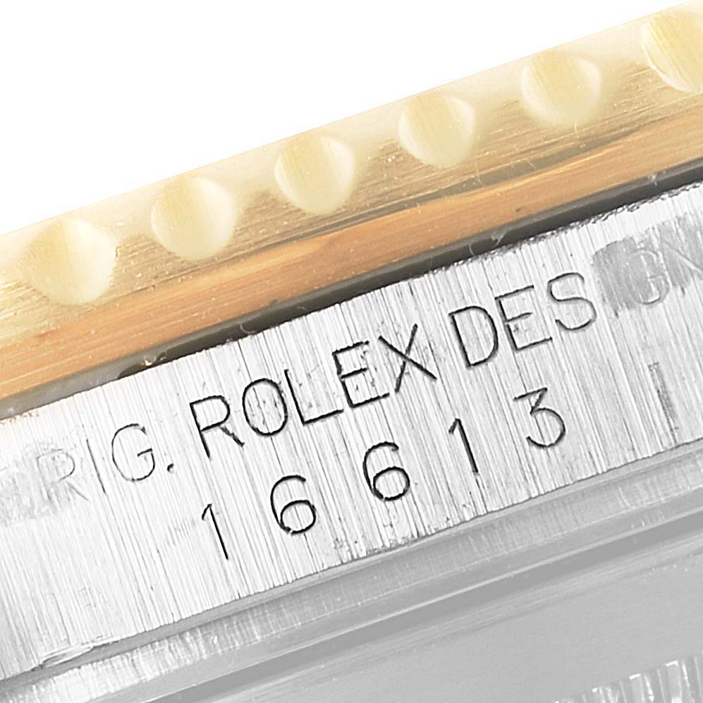 The image shows a close-up of the model number and part of the bezel of the Rolex Submariner 16613 Men's Steel and Gold (two tone) Blue Dial 16613 Men's Steel and Gold (two tone) Blue Dial.